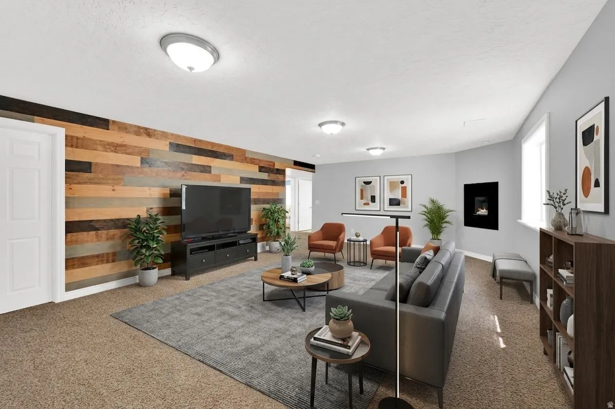 Spacious room featuring a multi-toned wood plank accent wall, wall-mounted electric fireplace, recessed lighting, and durable carpet flooring