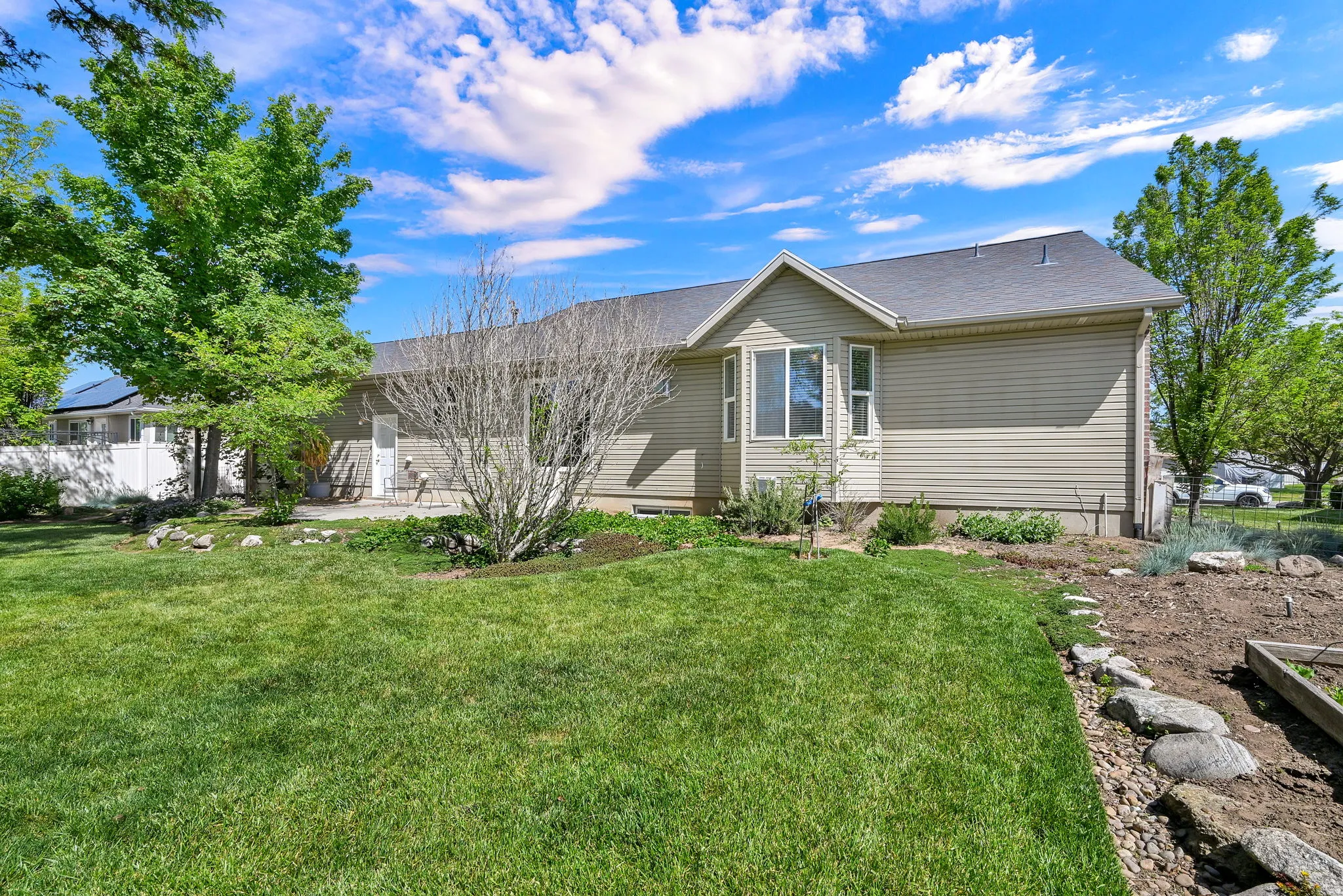 Expansive green lawn with established trees and shrubbery