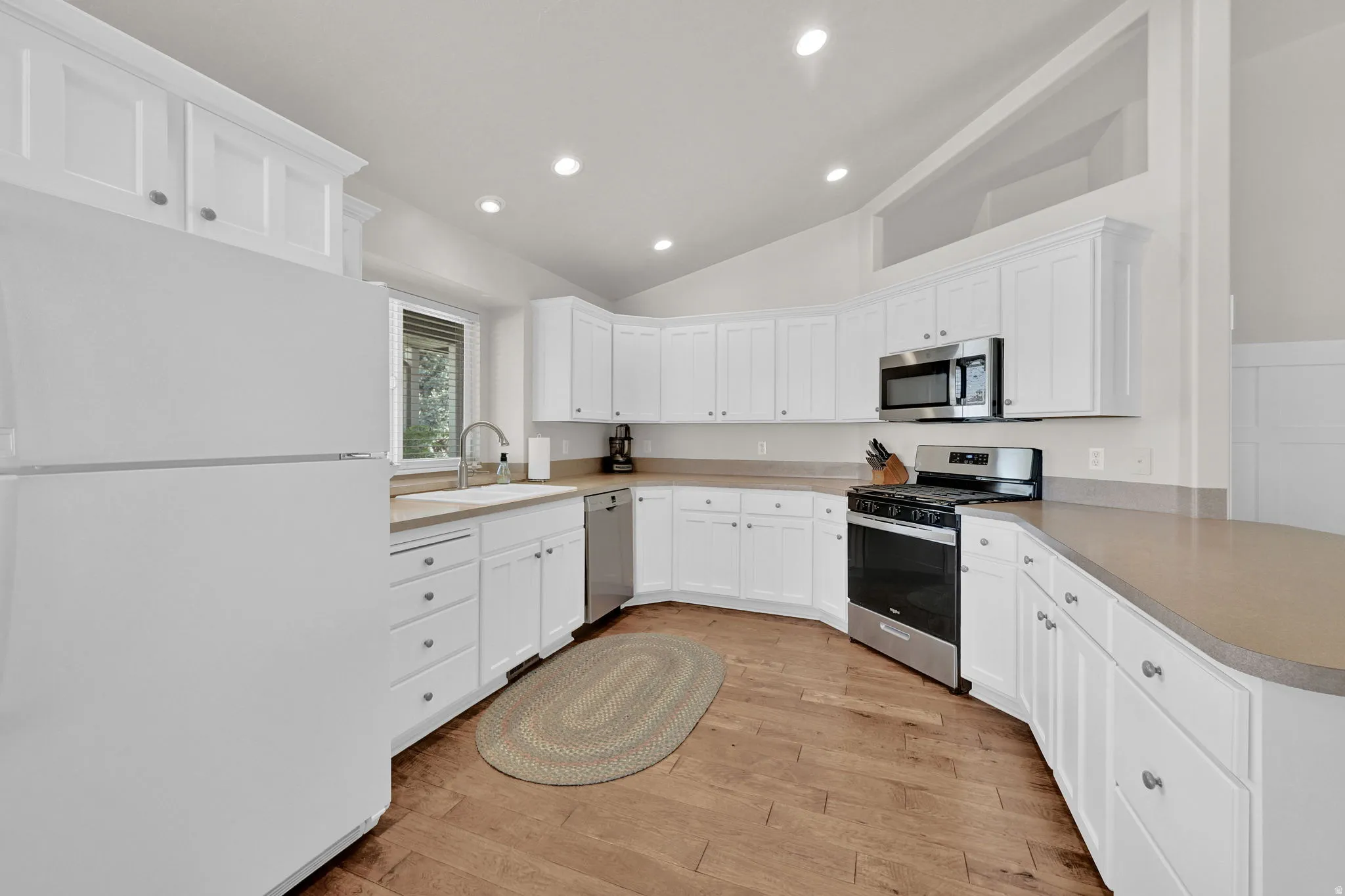 Kitchen featuring white cabinetry, light countertops, wood-finish flooring, and recessed lighting