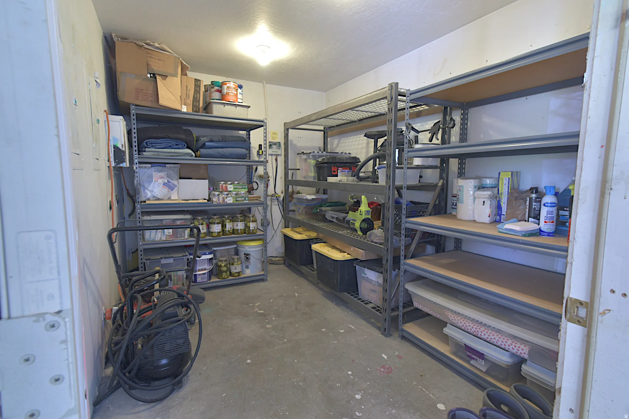 Dedicated storage area featuring concrete flooring and built-in metal shelving units