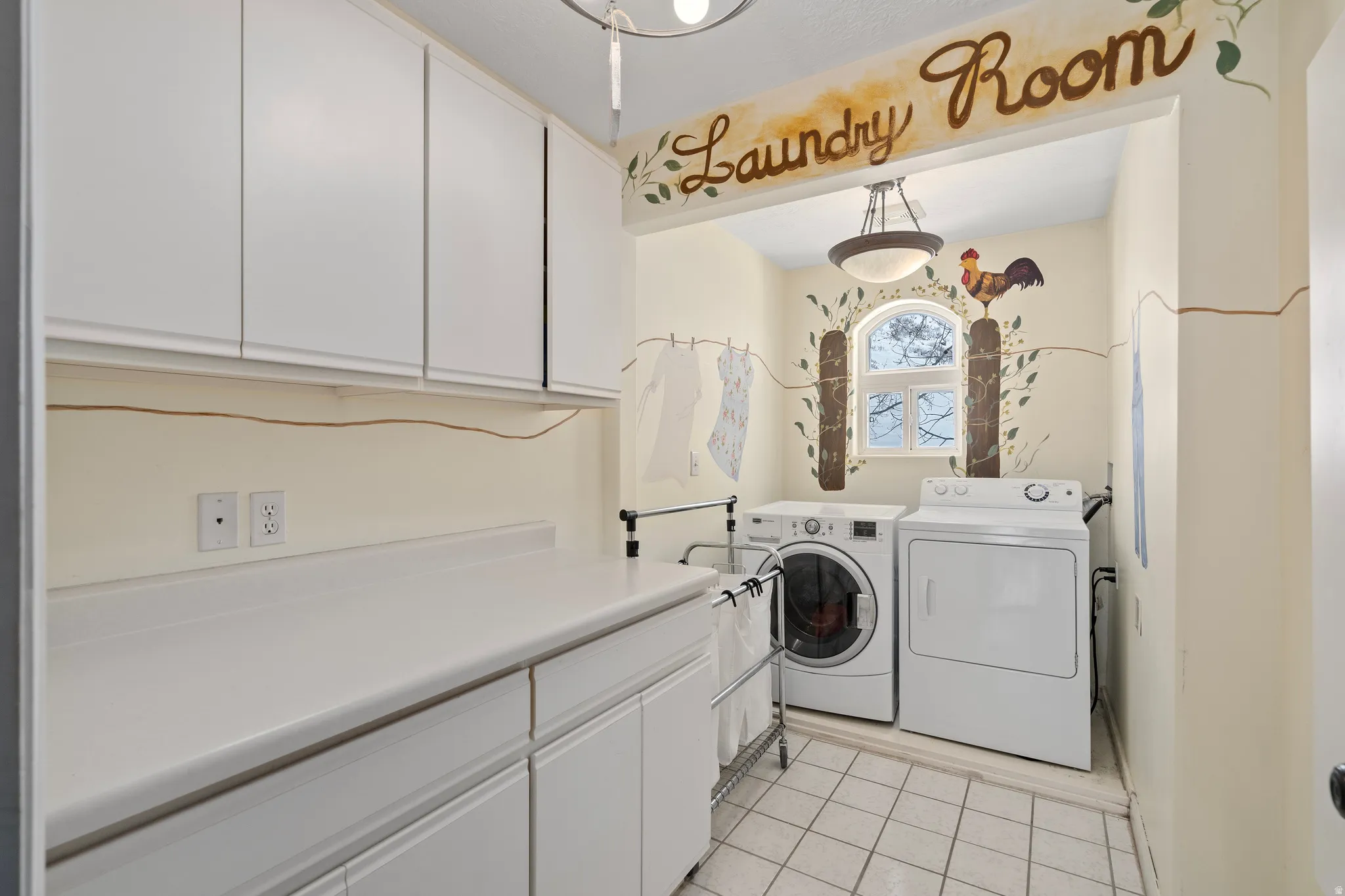 Dedicated laundry room featuring white cabinetry, a spacious countertop, and tile flooring