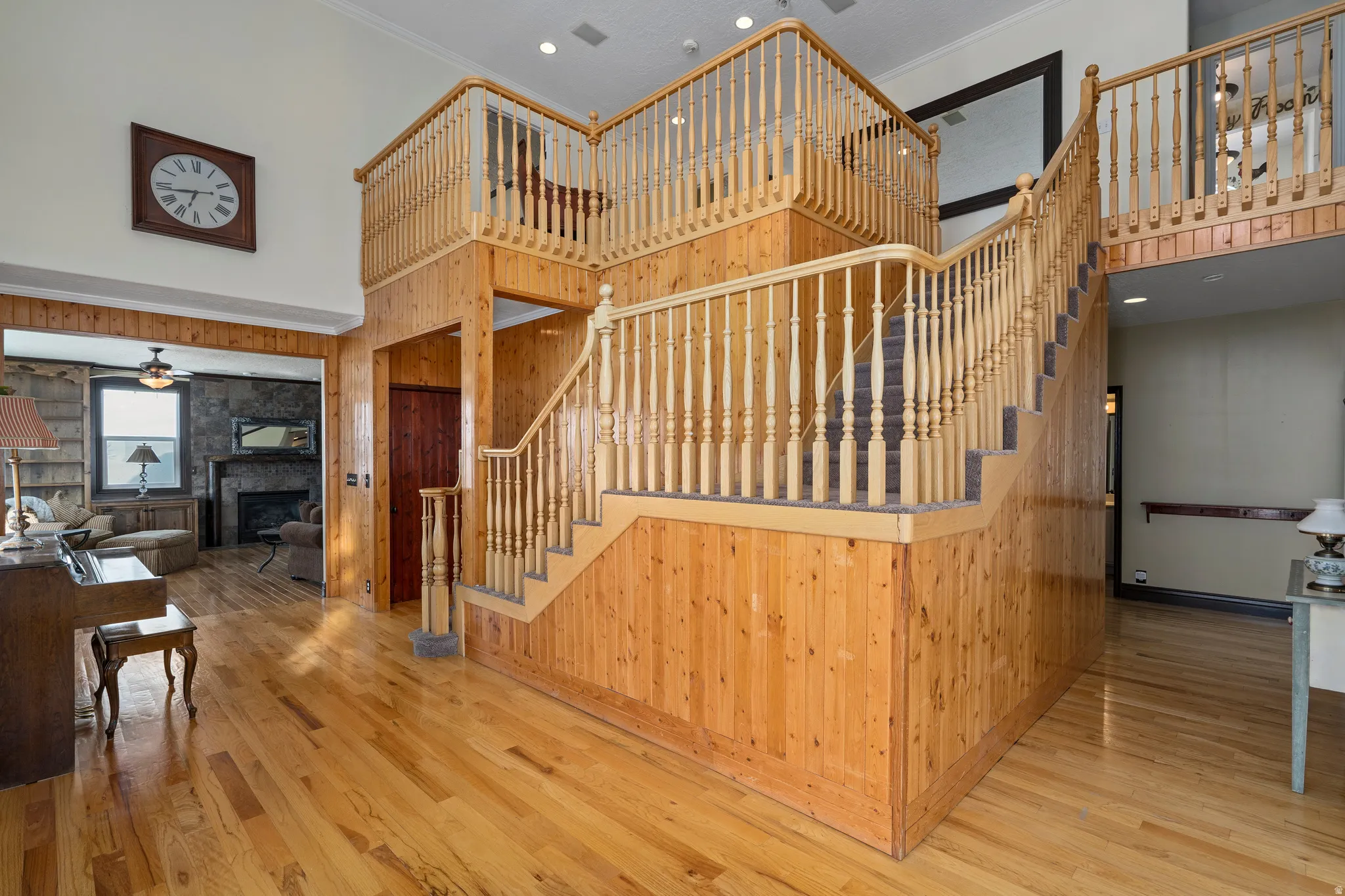 Two-story entry featuring extensive wood-paneled walls and matching wood-finish flooring