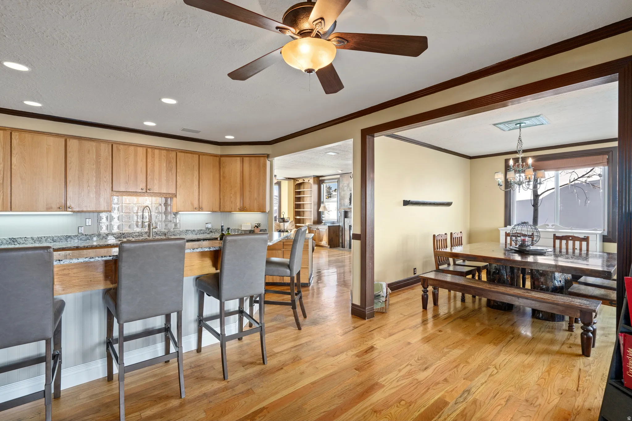Kitchen with light wood cabinetry, granite countertops, and a tile backsplash