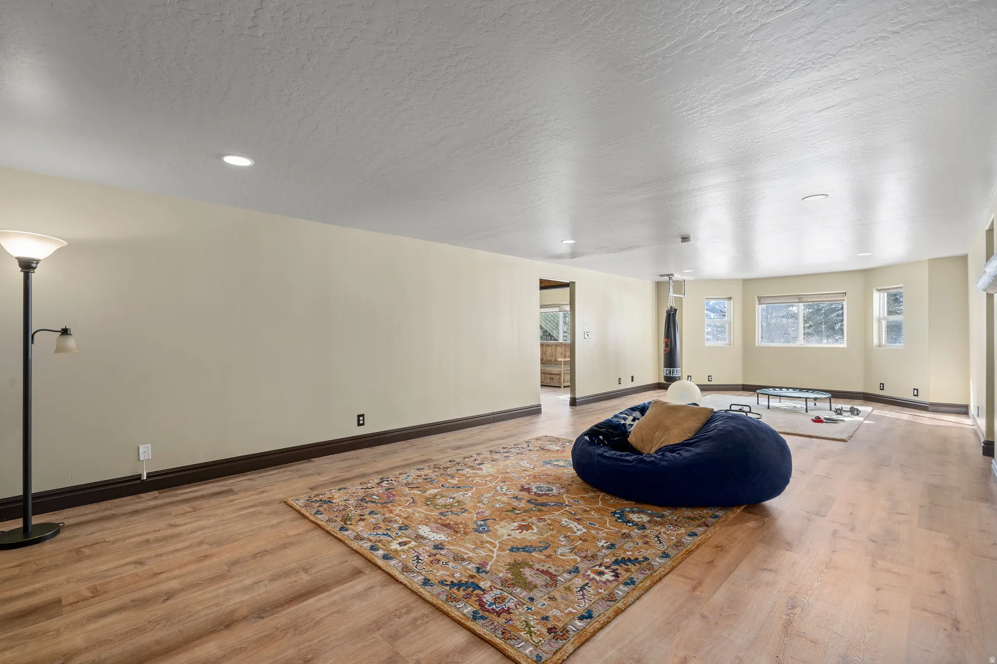 Spacious room featuring wood-finish flooring, recessed lighting, and a neutral color palette