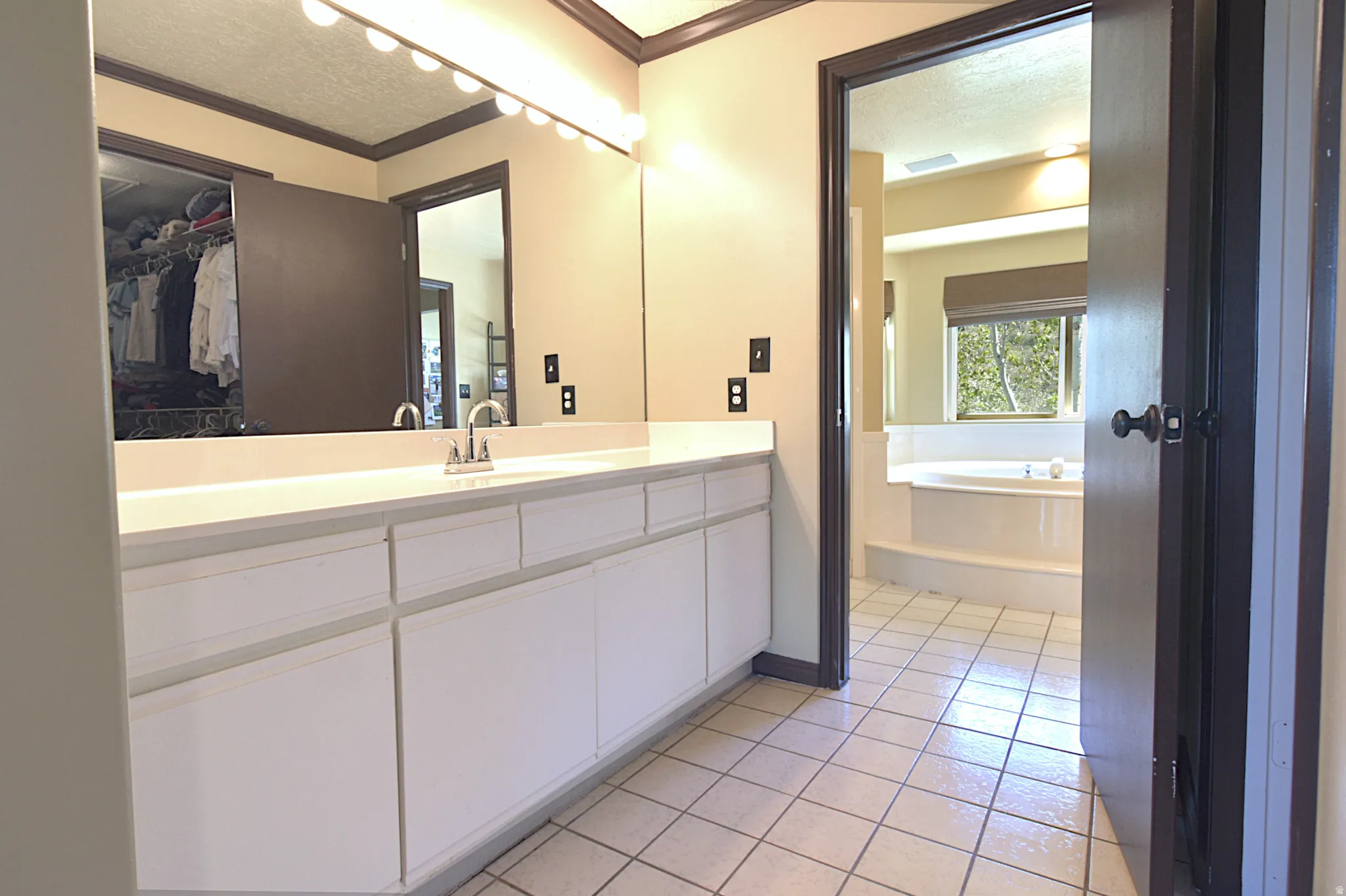 Bathroom vanity featuring an expansive white countertop and integrated sink