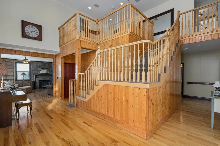 Two-story entry featuring extensive wood-paneled walls and matching wood-finish flooring