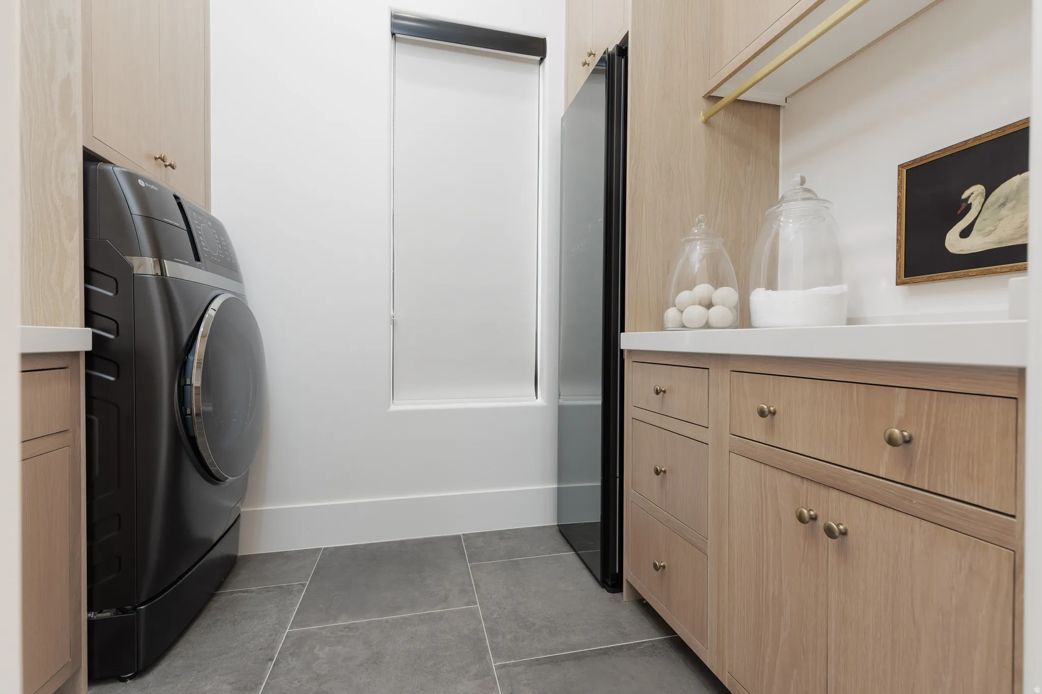 Laundry area featuring cabinet space, washer / dryer, and light tile patterned floors