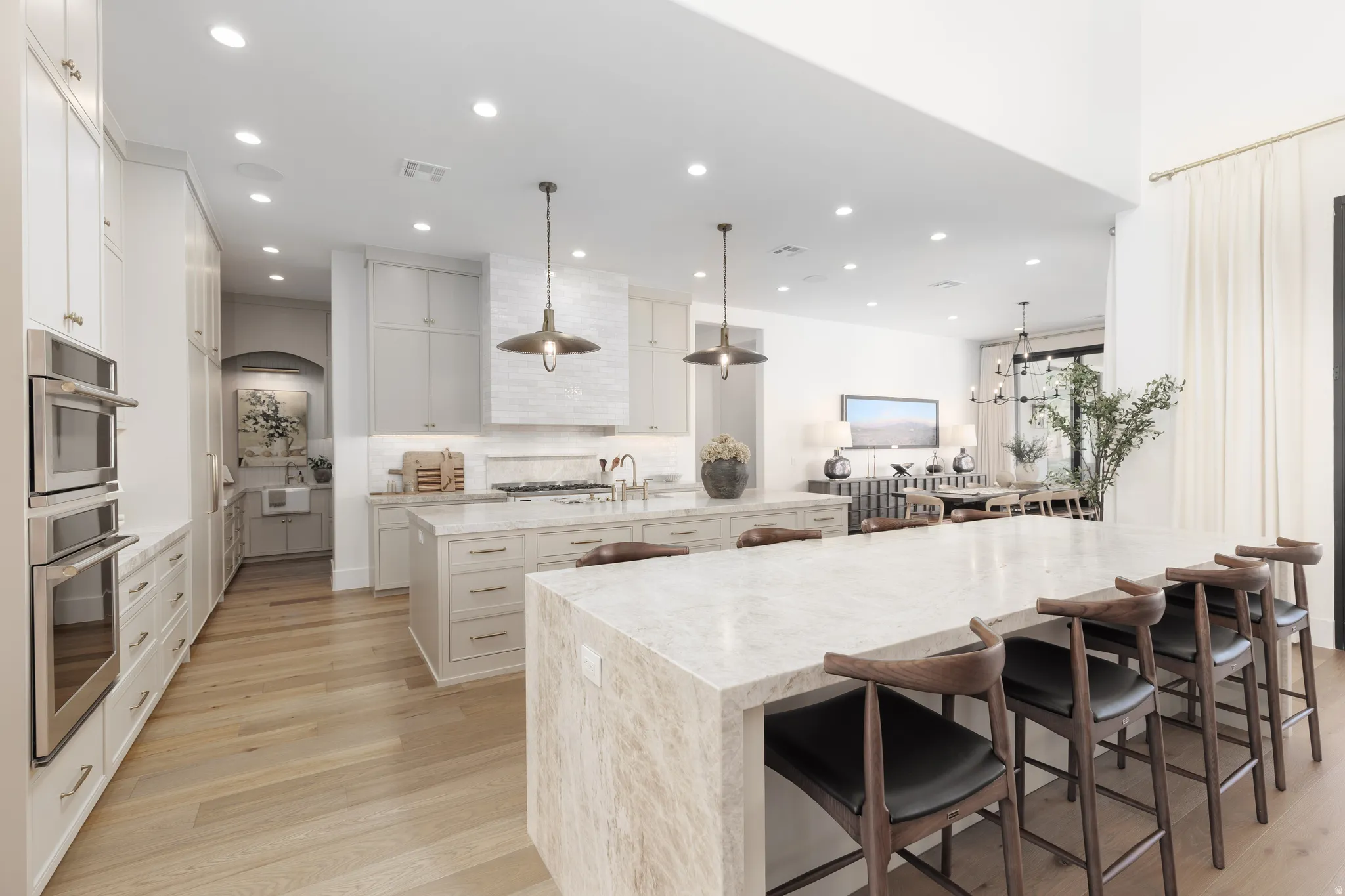 Kitchen featuring light stone counters, a breakfast bar, light wood-type flooring, and tasteful backsplash