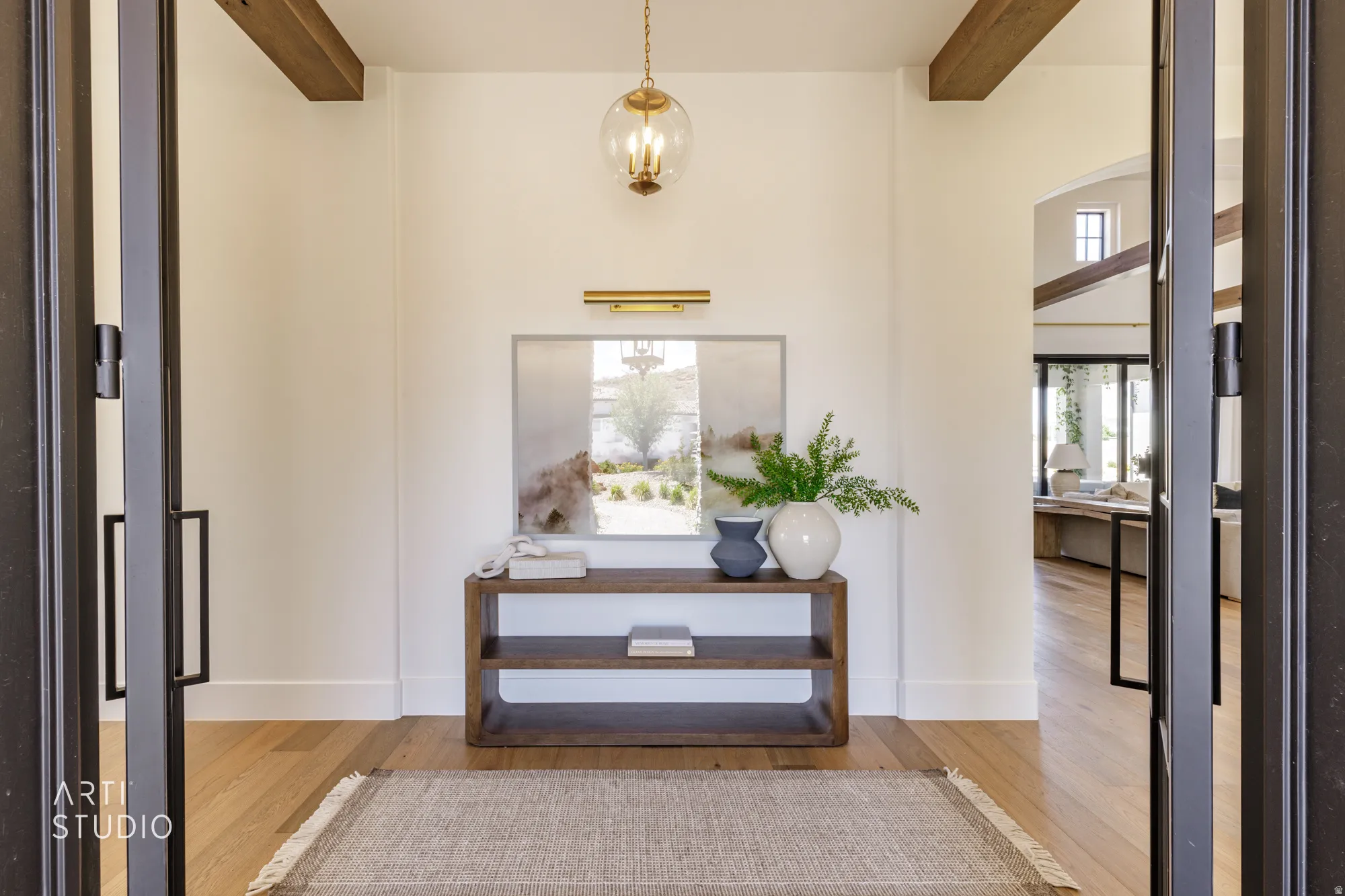 Foyer with exposed wood beams and a glass globe chandelier