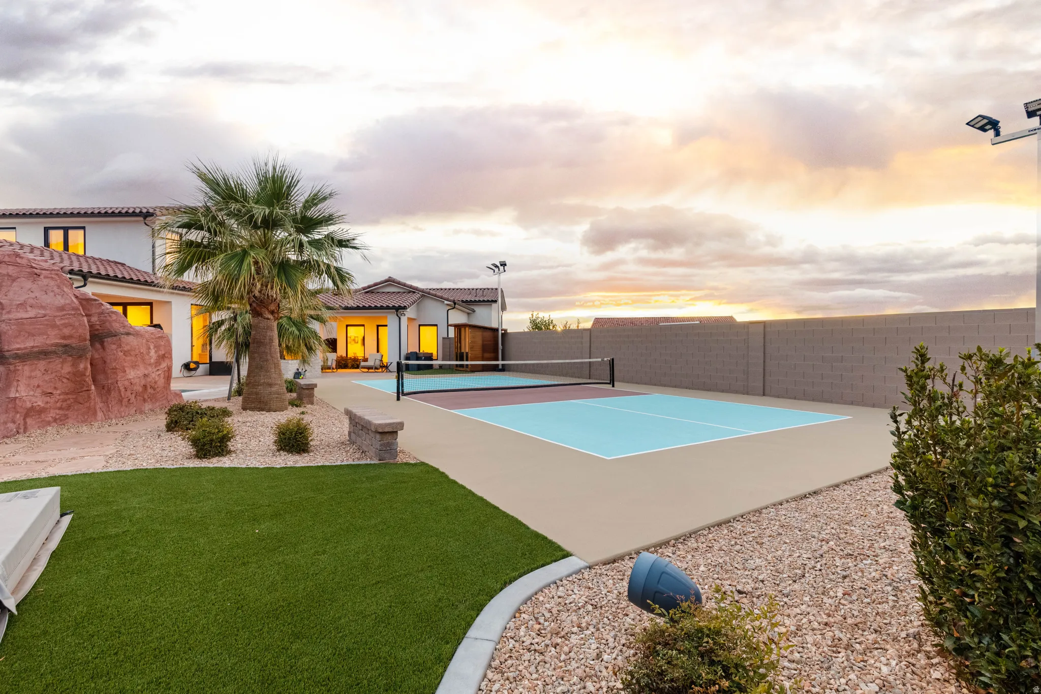 View of tennis court featuring a fenced backyard and a patio