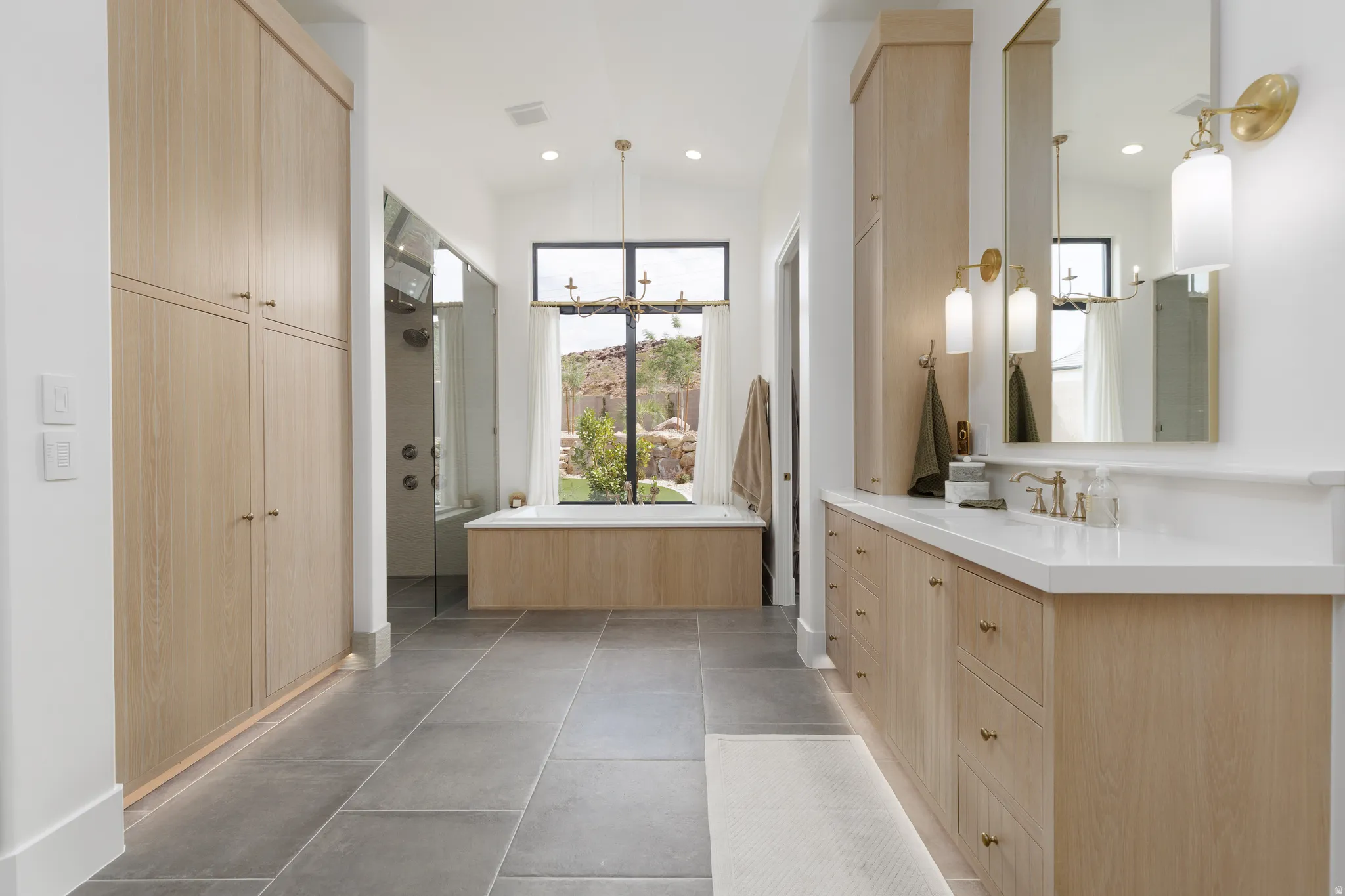 Bathroom featuring a shower stall, vanity, suspended lighting, lofted ceiling, and dark tile patterned floors