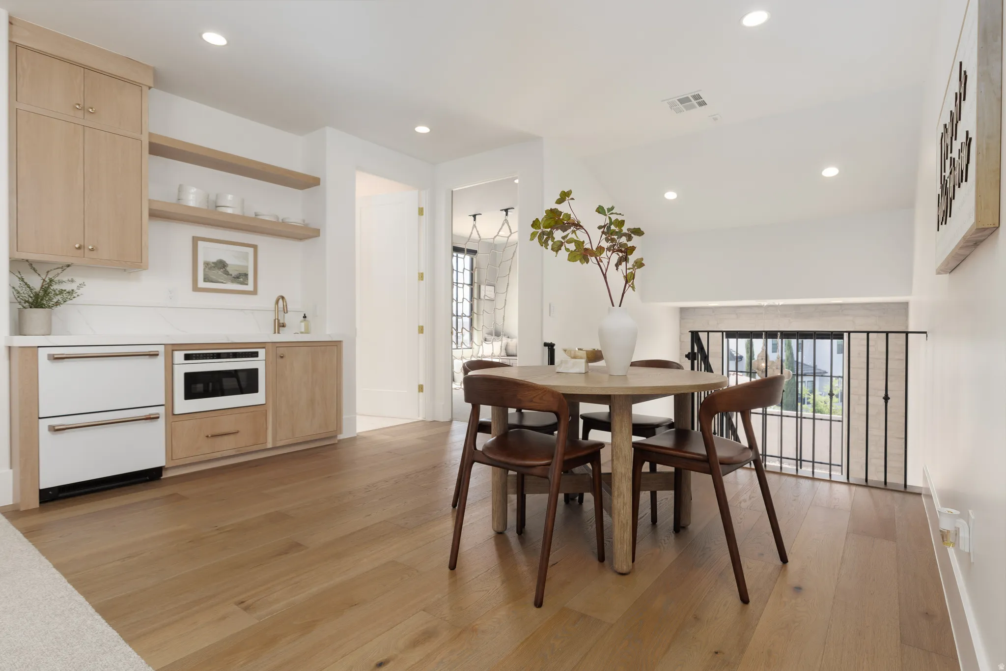 Dining space with light wood finished floors, vaulted ceiling, and recessed lighting