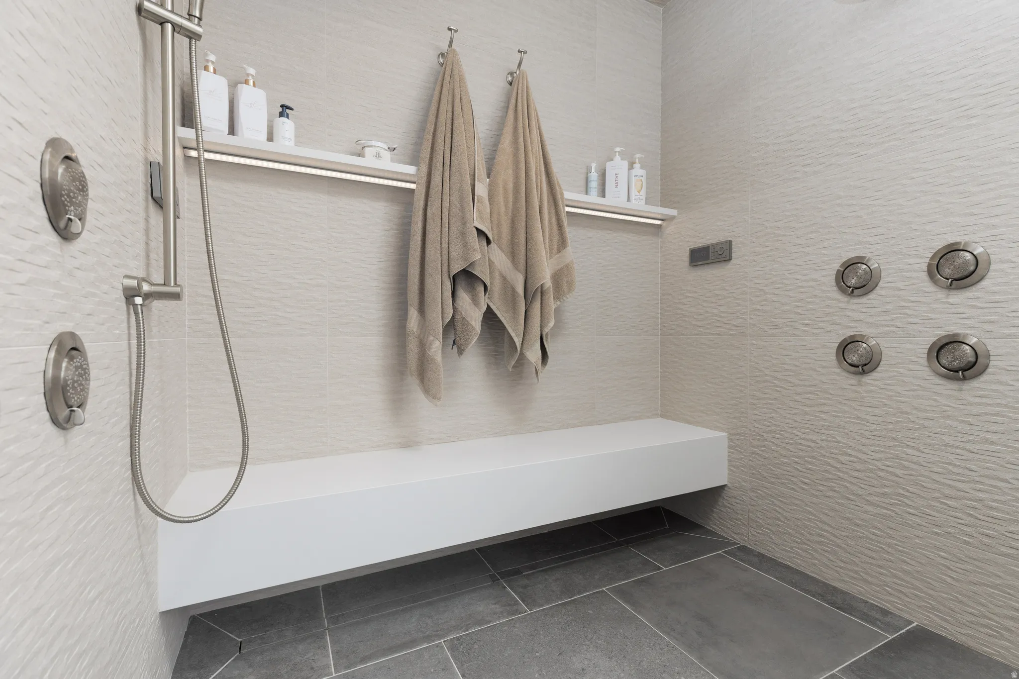 Full bathroom with dark tile patterned flooring and a shower