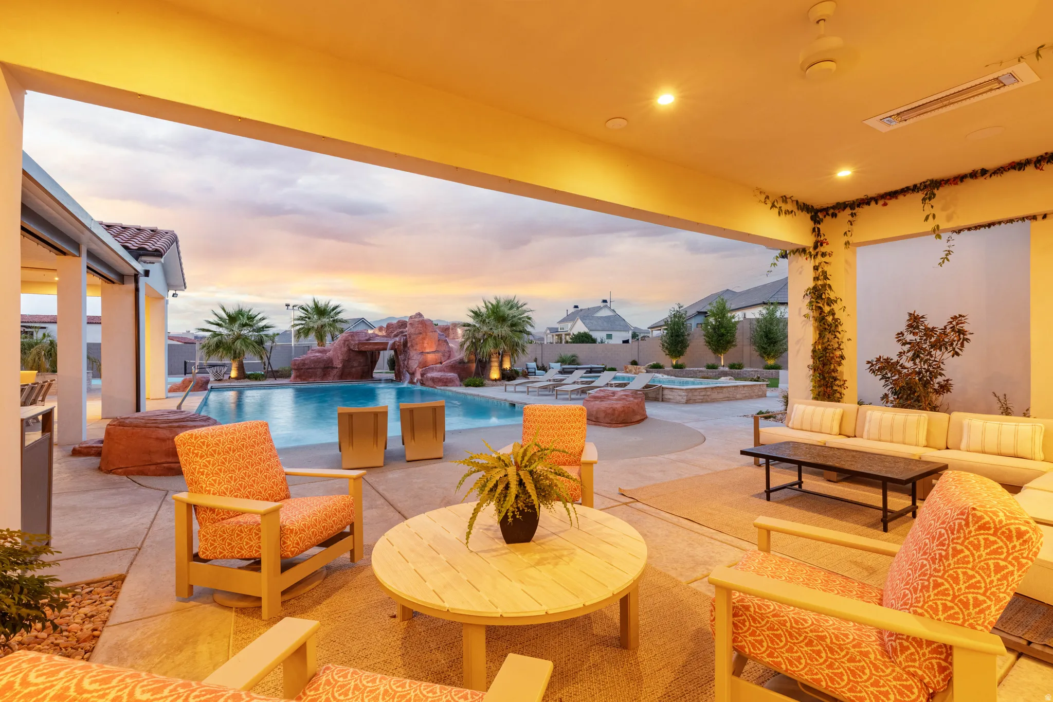 Patio terrace at dusk featuring an outdoor pool, a jacuzzi, a patio area, outdoor furniture, and a fenced backyard