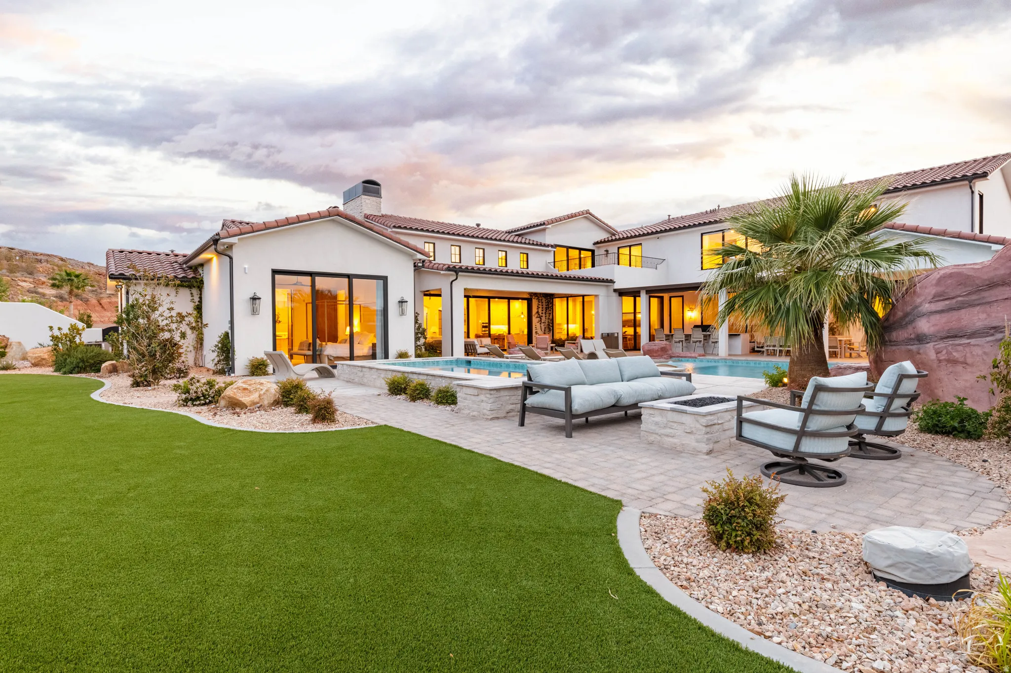 Back of house featuring an outdoor living space with a fire pit, a patio, an outdoor pool, a tiled roof, and stucco siding