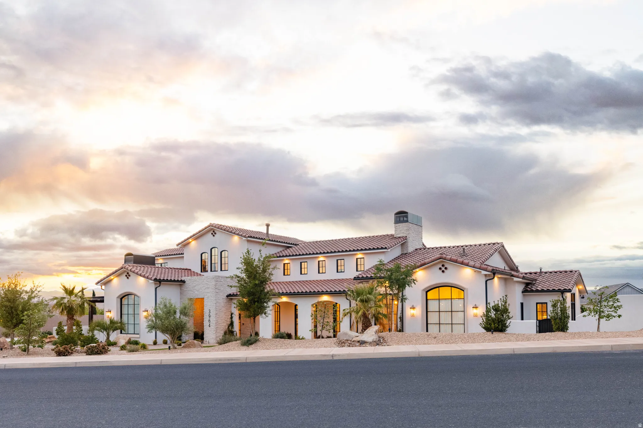 Mediterranean / spanish-style house featuring a chimney, stucco siding, and a tiled roof