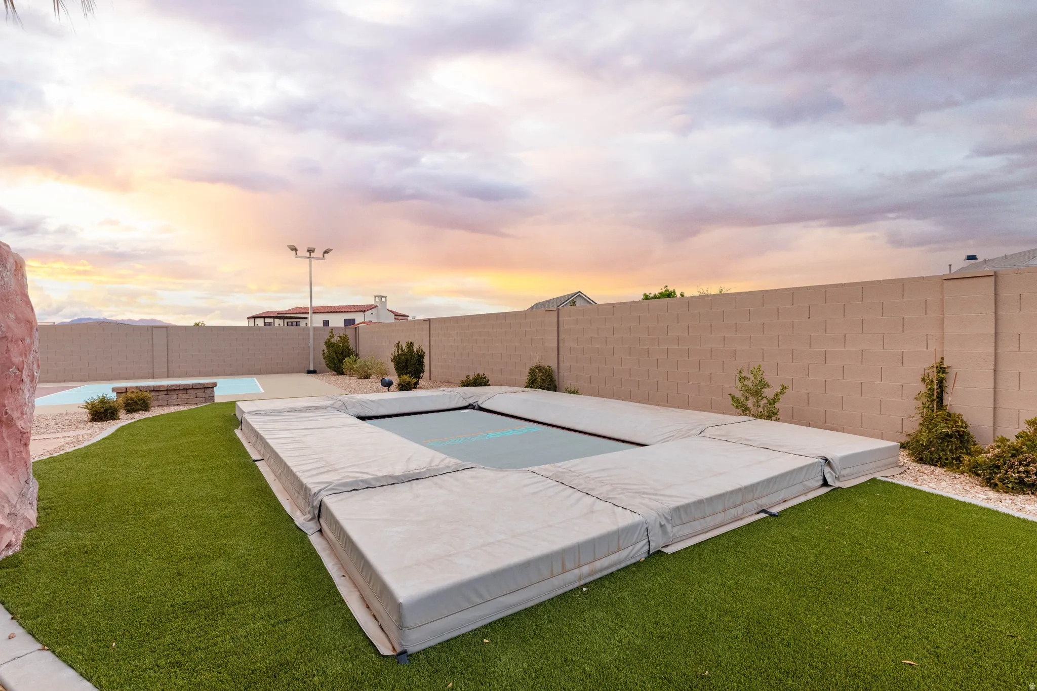 Pool at dusk with a fenced backyard
