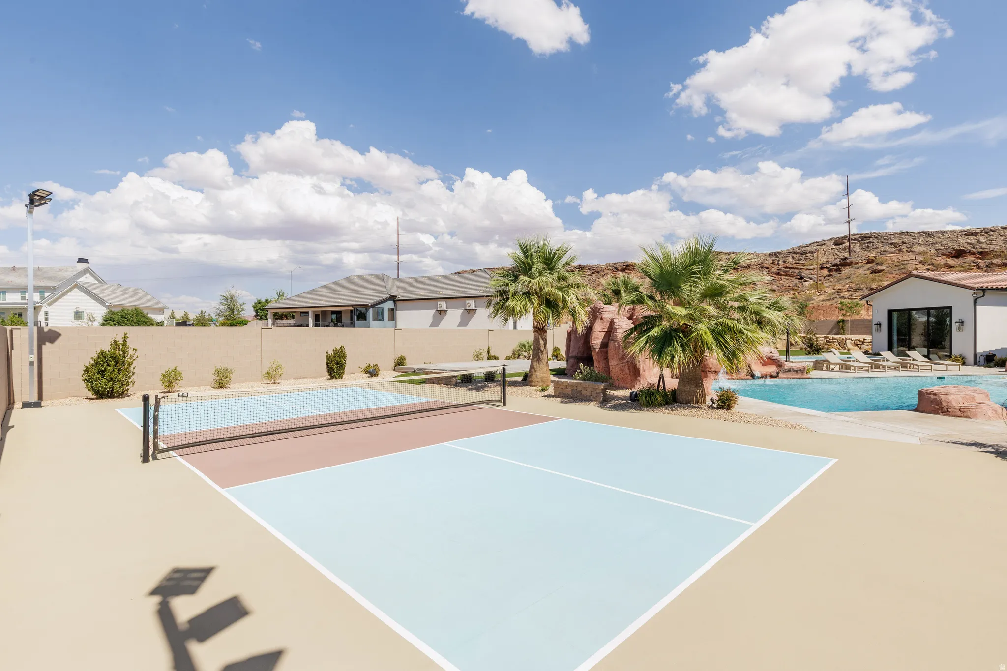 View of tennis court featuring a patio area