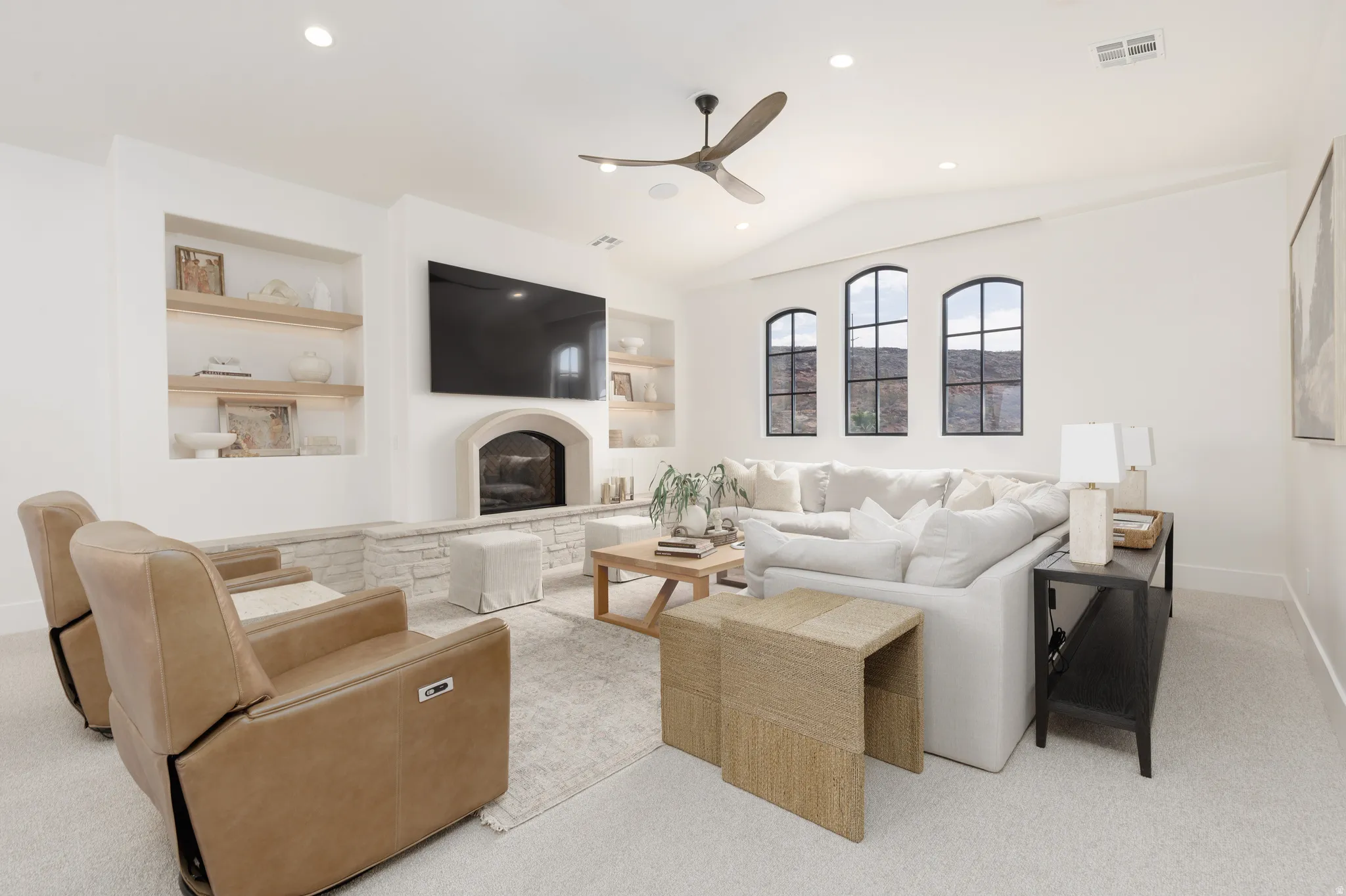 Living area featuring built in features, ceiling fan, light carpet, recessed lighting, and a glass covered fireplace