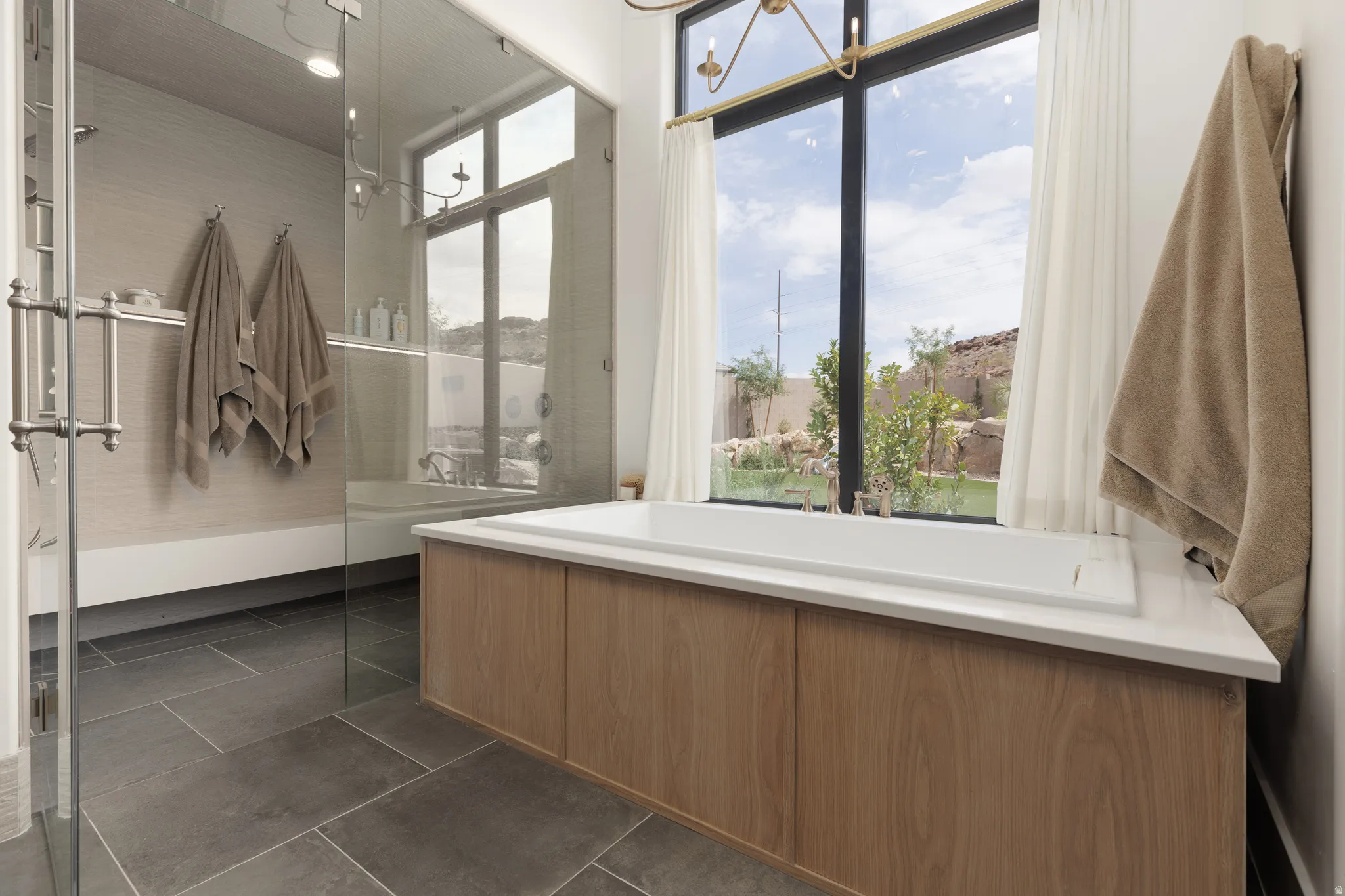 Full bath with a bath, dark tile patterned flooring, and walk in shower