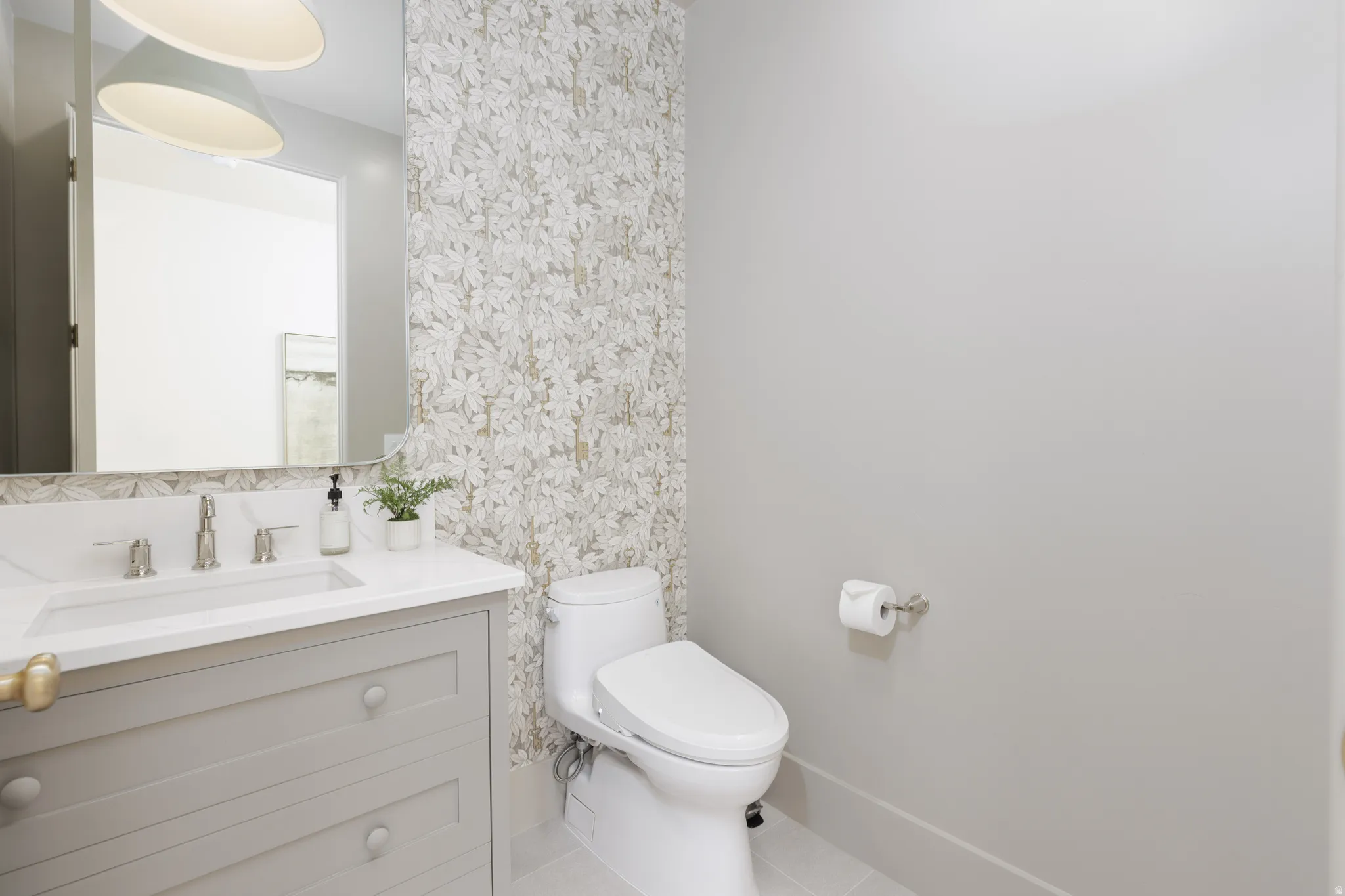 Bathroom featuring vanity, light tile patterned floors, and wallpapered walls