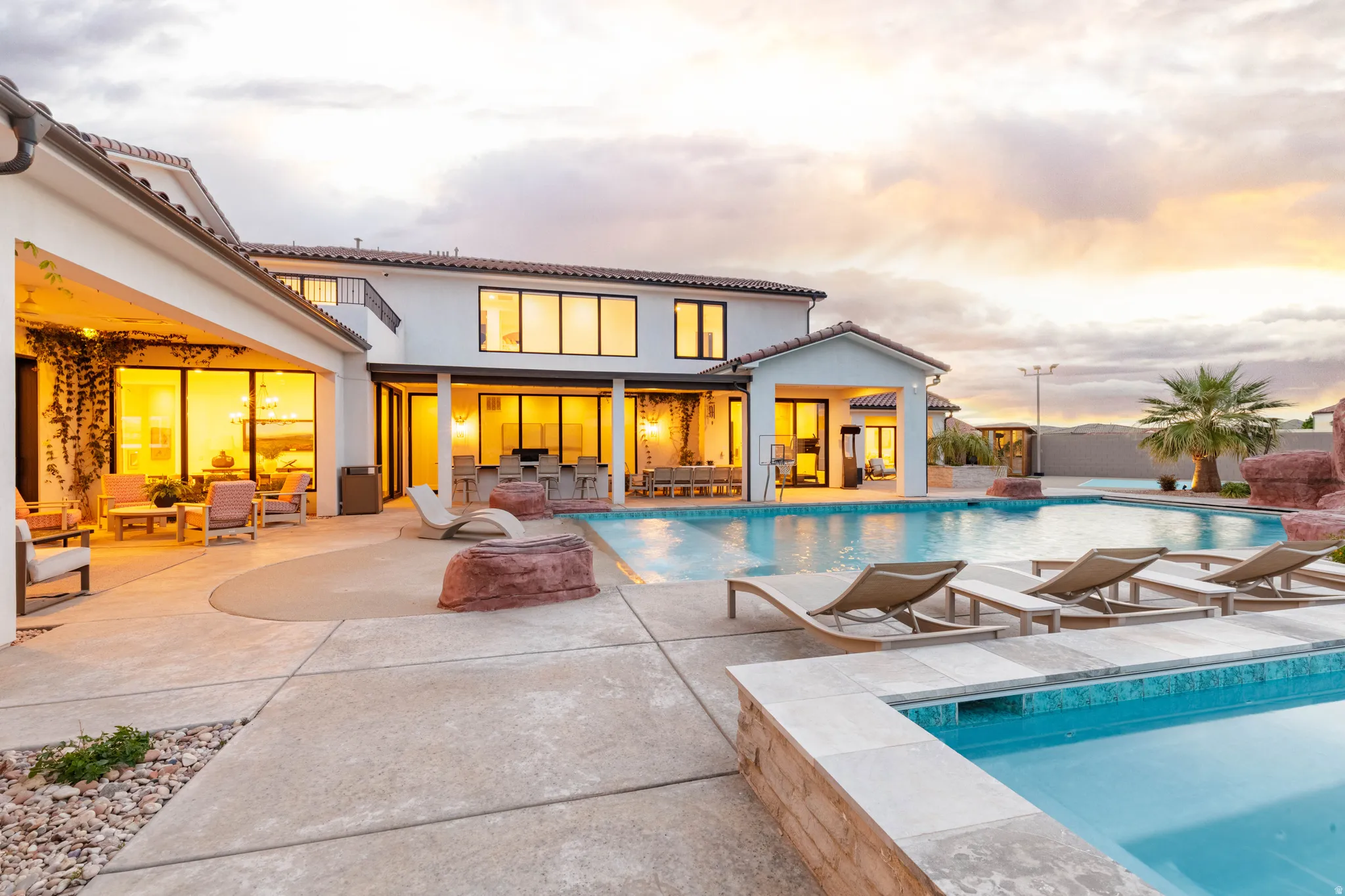 Back of property featuring outdoor seating, a patio area, an outdoor pool, and a tiled roof