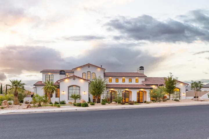 Mediterranean / spanish home with a tiled roof, stucco siding, and a chimney