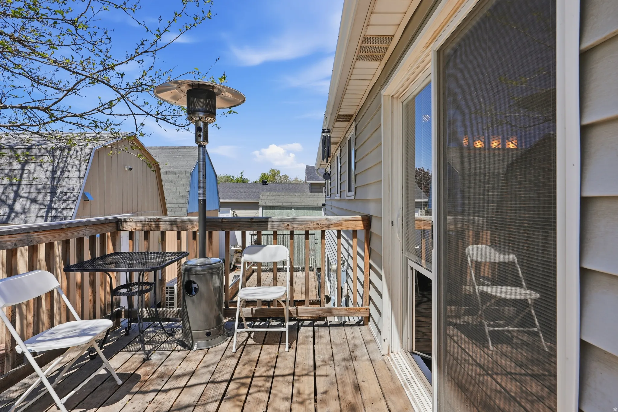 Outdoor wood deck featuring a protective wood railing, siding exterior, and a sliding glass door with a screen