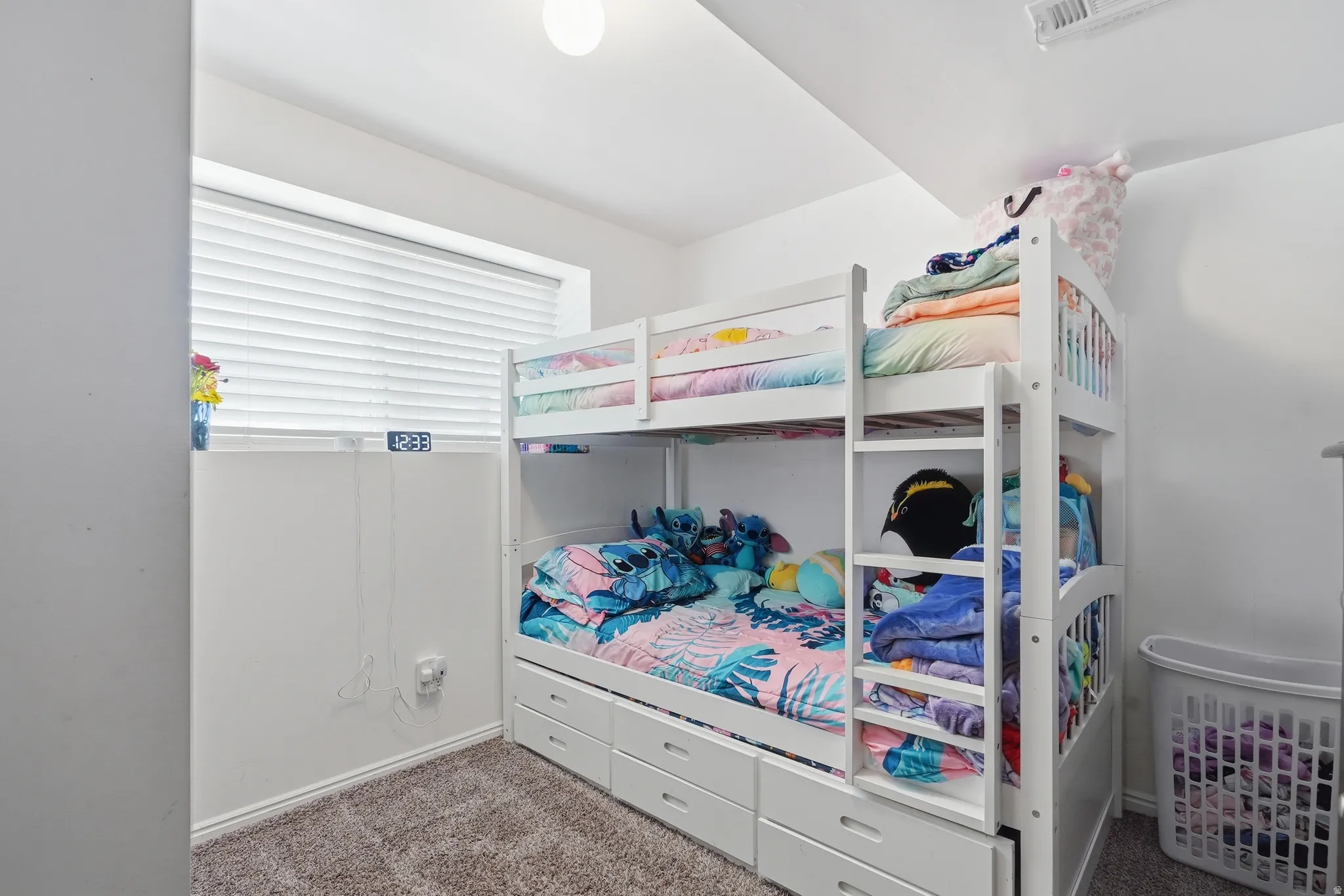 Bedroom featuring white walls, a single window with horizontal blinds, and gray carpet flooring