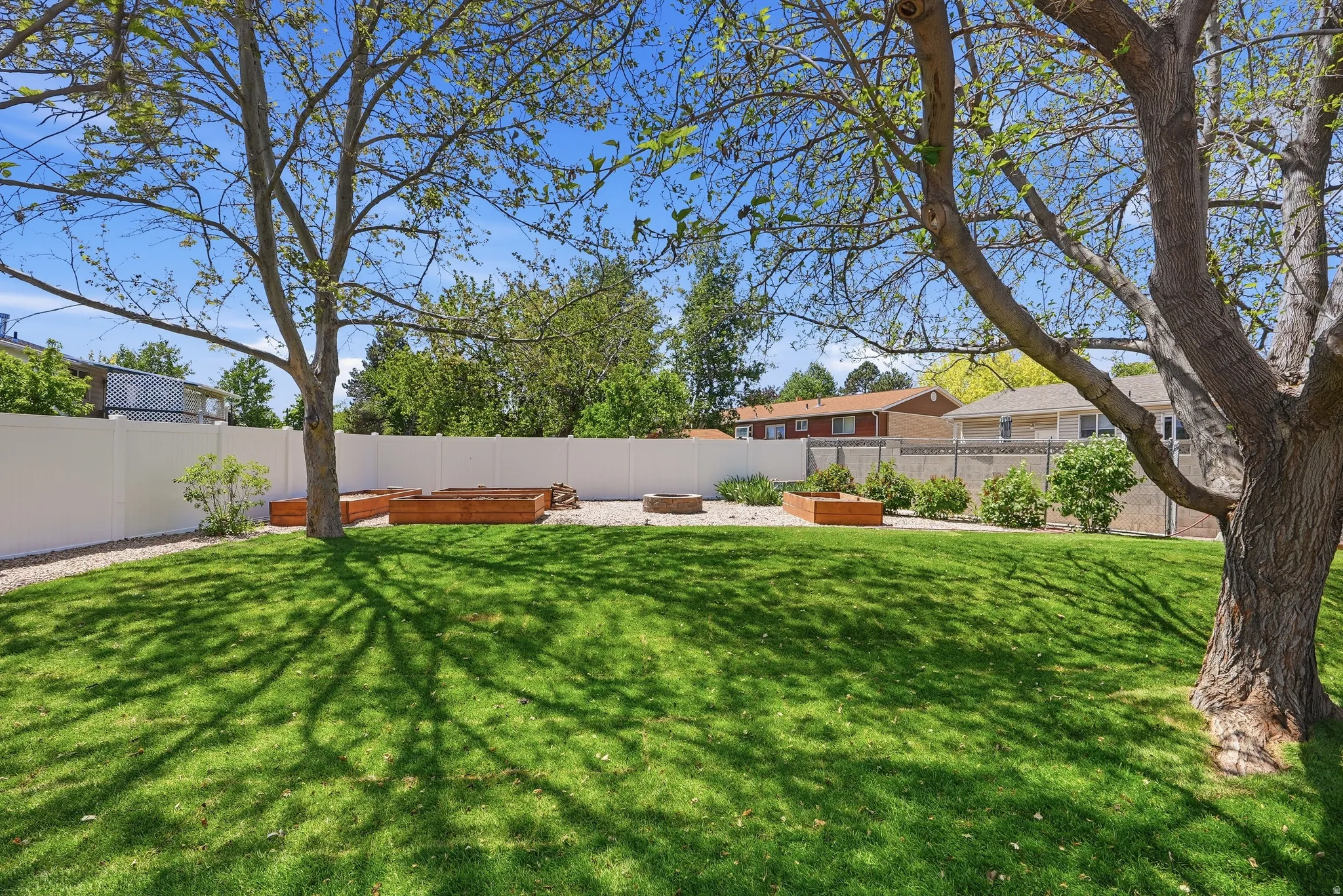 Expansive lawn area with mature trees providing dappled shade