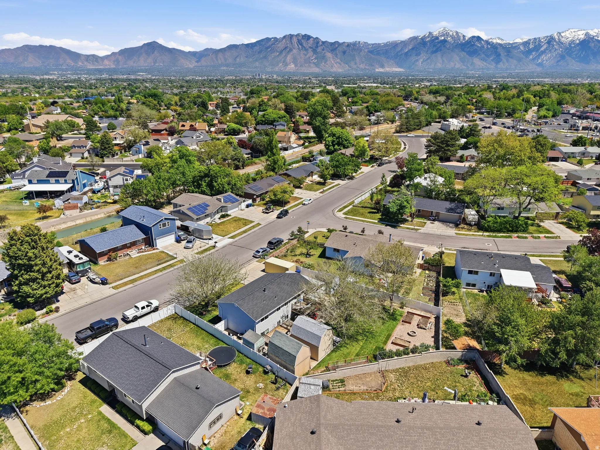 Residential neighborhood with mature trees, established streets, and mountain scenery