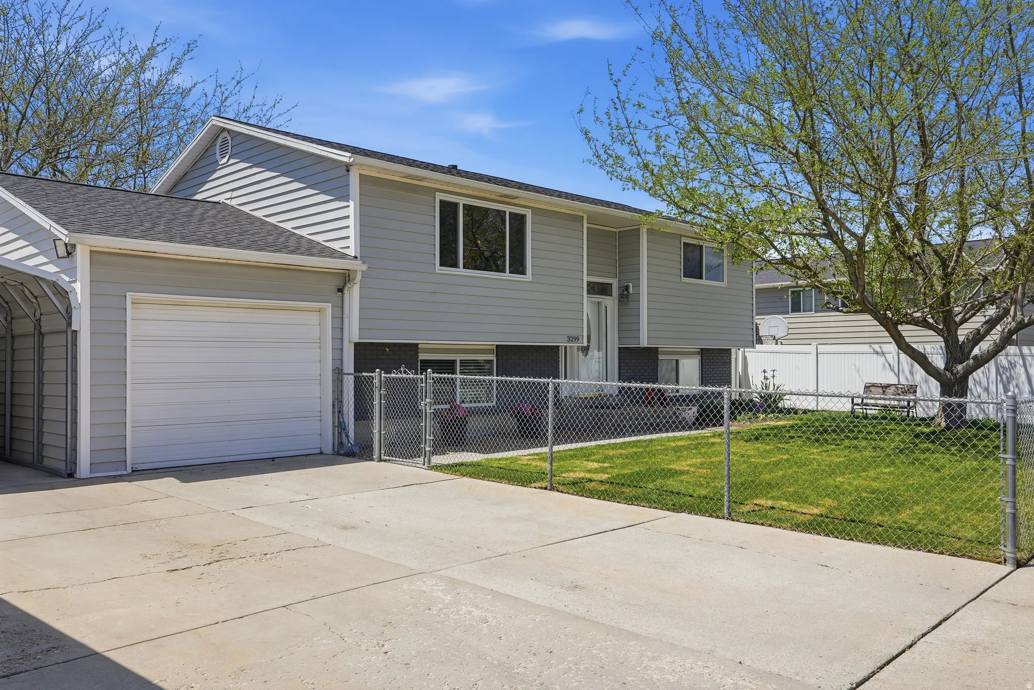 Split-level residence featuring light gray siding with dark gray lower accents