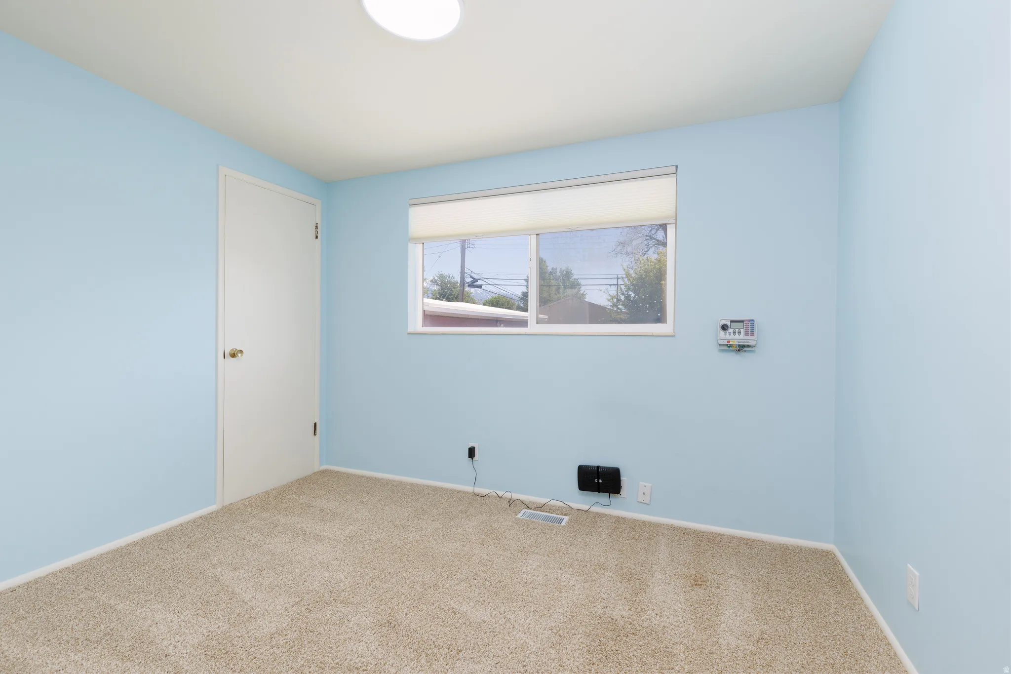 Bedroom #2 featuring light blue walls, tan carpeting, and a white ceiling