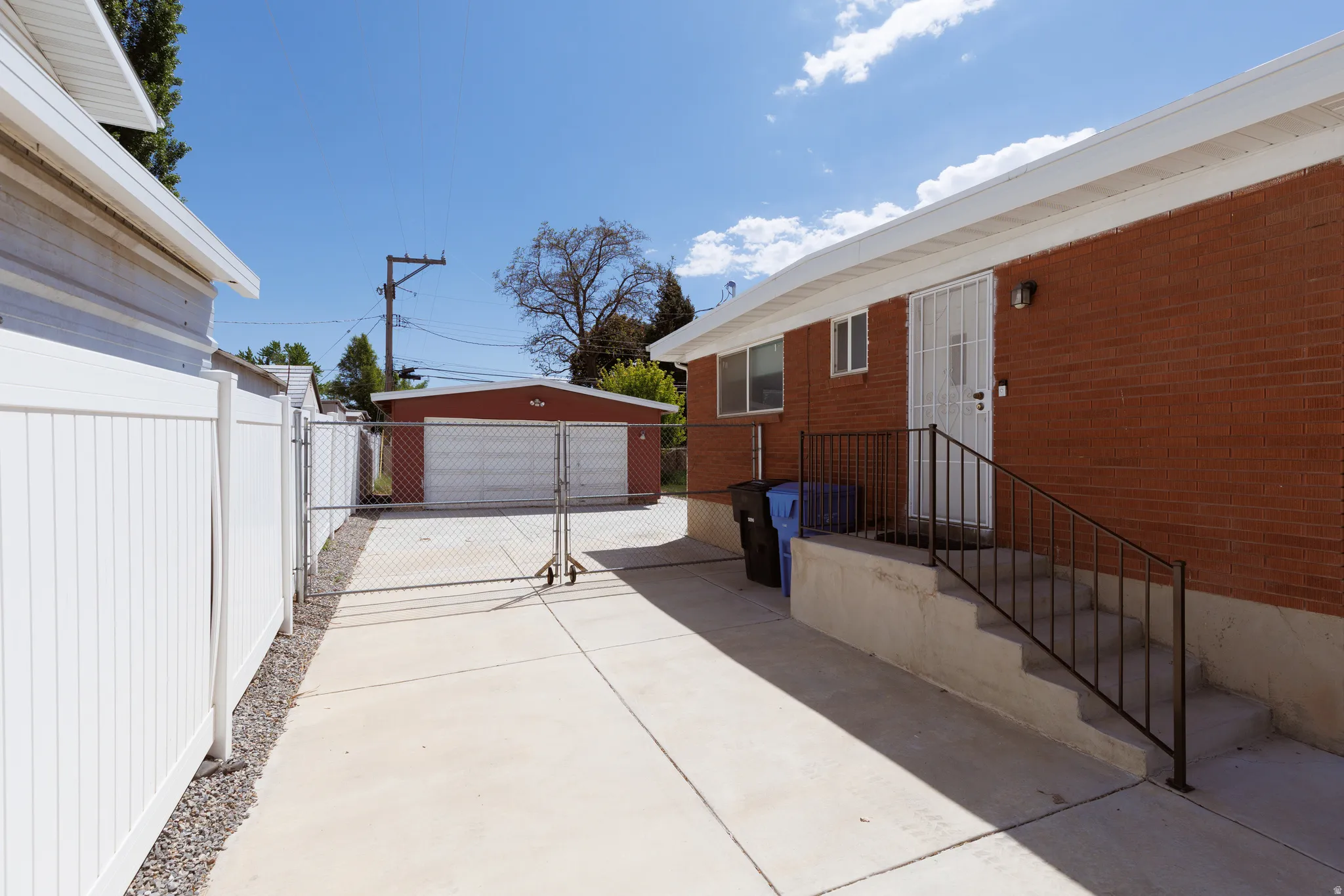 Concrete driveway extending to a detached garage with two garage doors