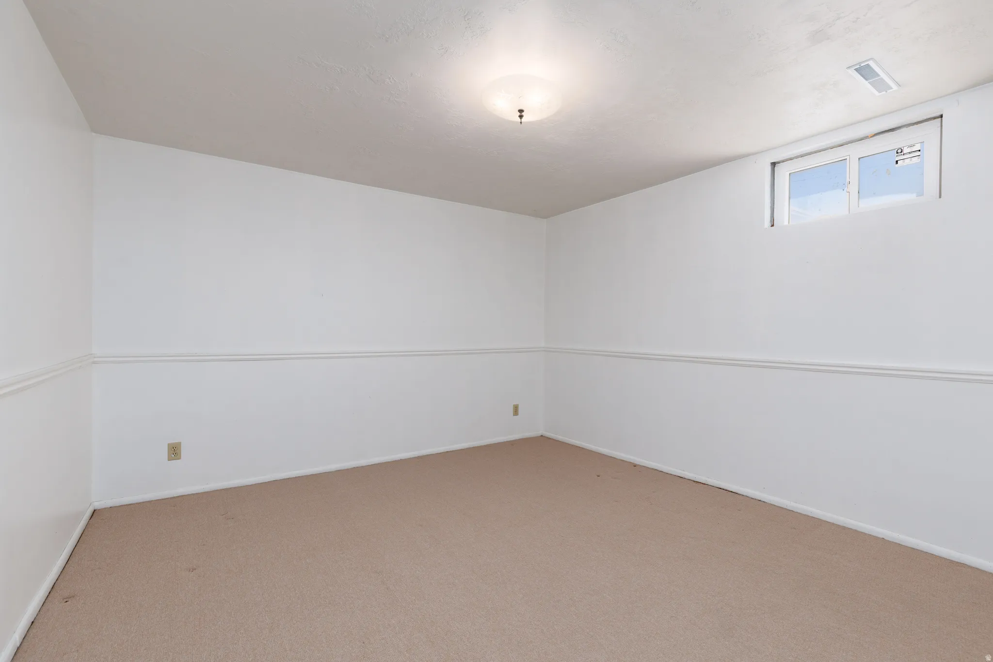Bedroom #4 featuring white walls, a single window, and a flush-mount ceiling light fixture