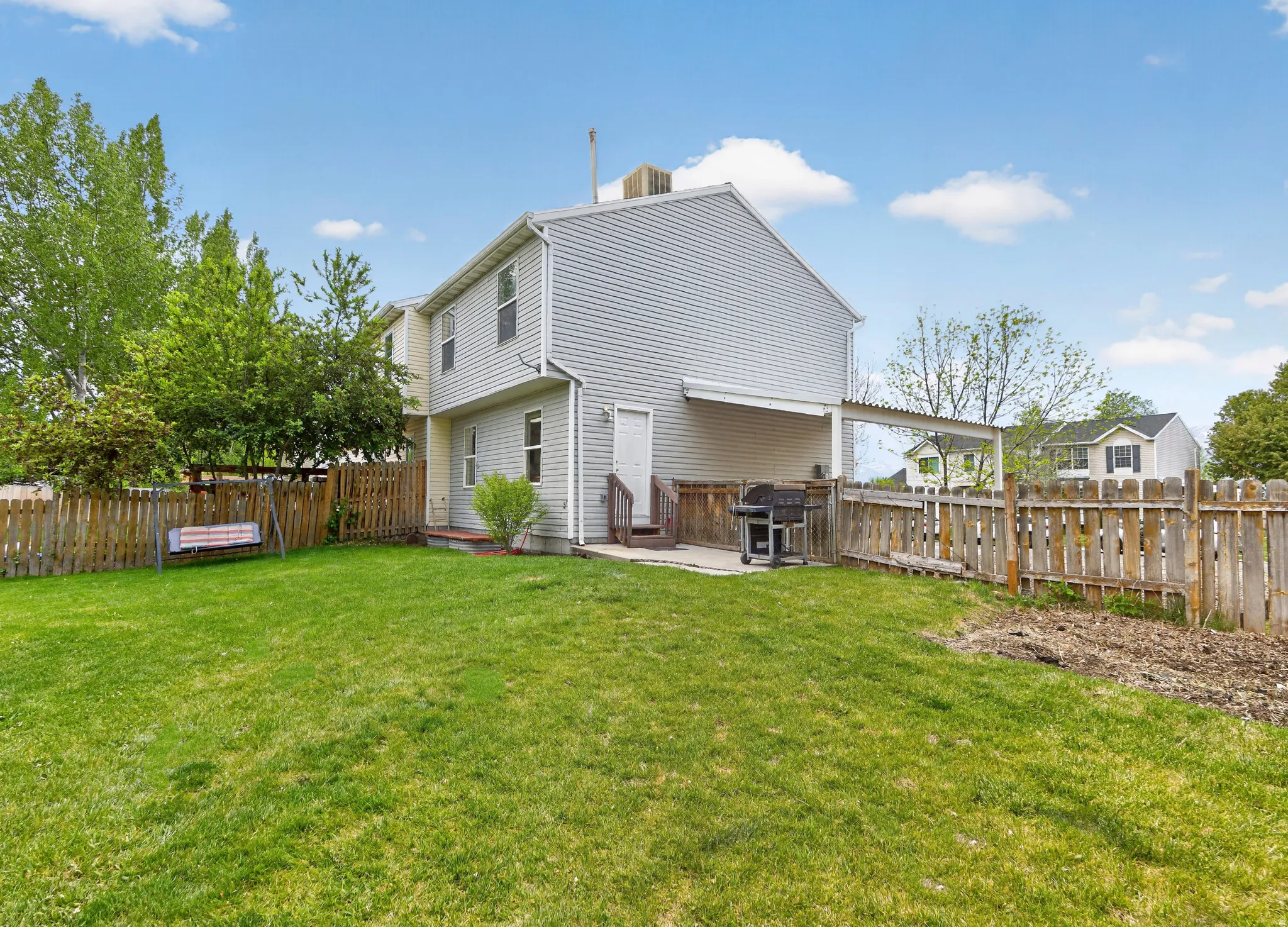 Expansive green lawn with a wooden privacy fence