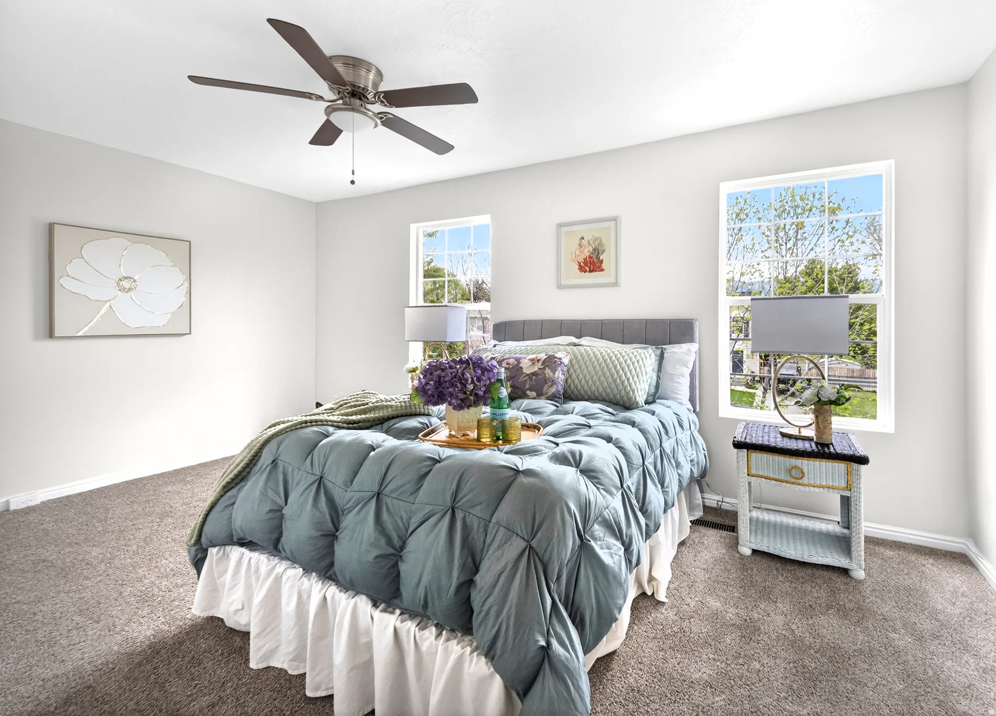 Bedroom featuring neutral carpeting, white walls, and a ceiling fan with integrated lighting