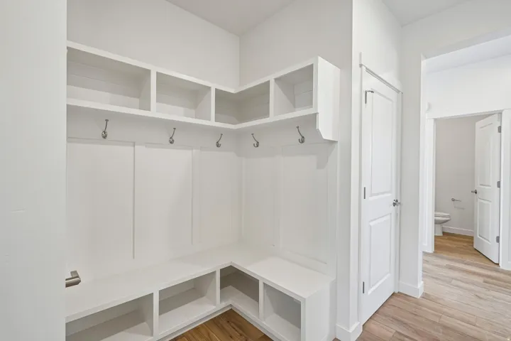 Built-in mudroom seating with storage, upper shelving, and coat hooks