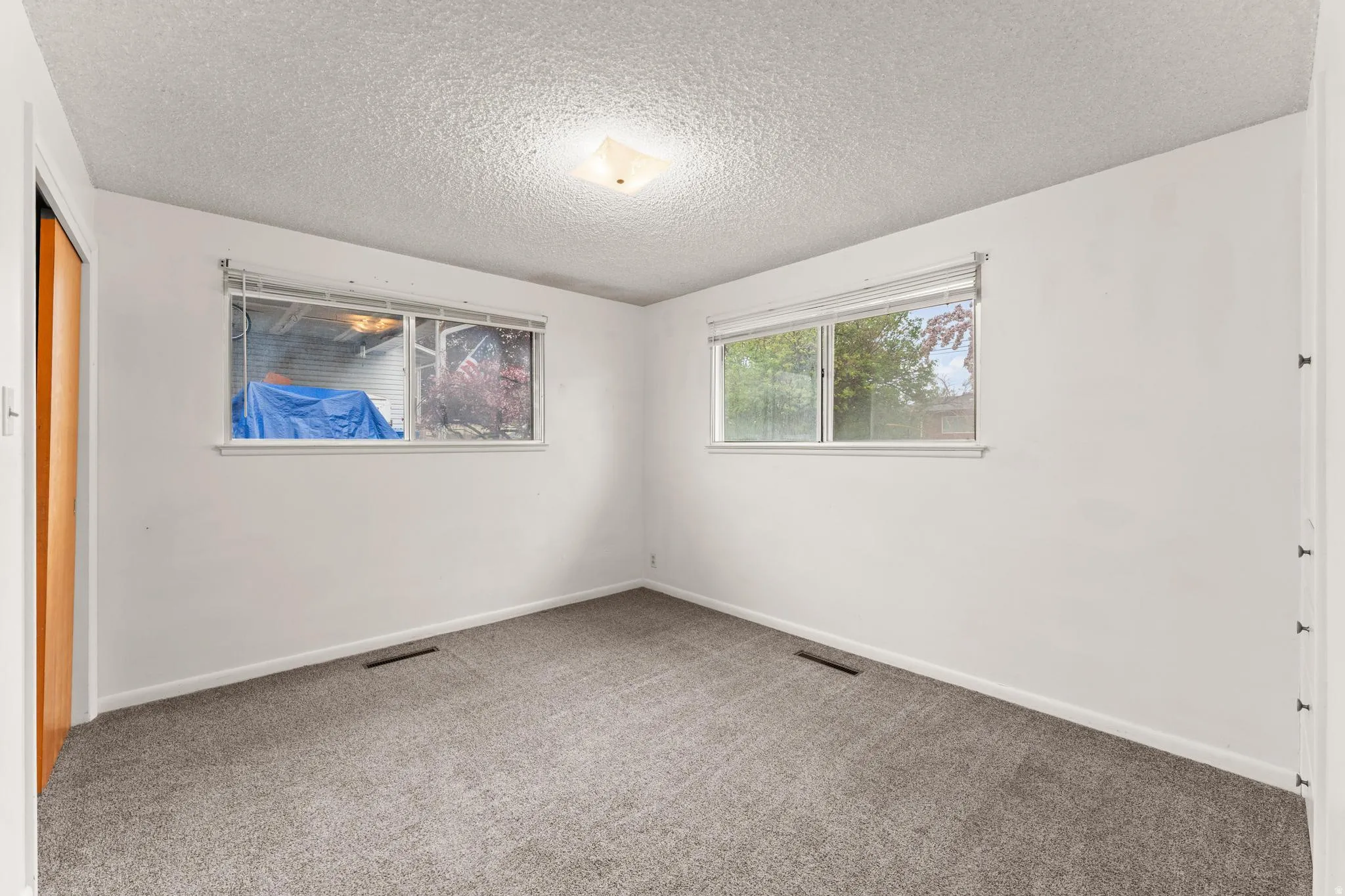 Unfurnished bedroom featuring a closet, carpet floors, and a textured ceiling