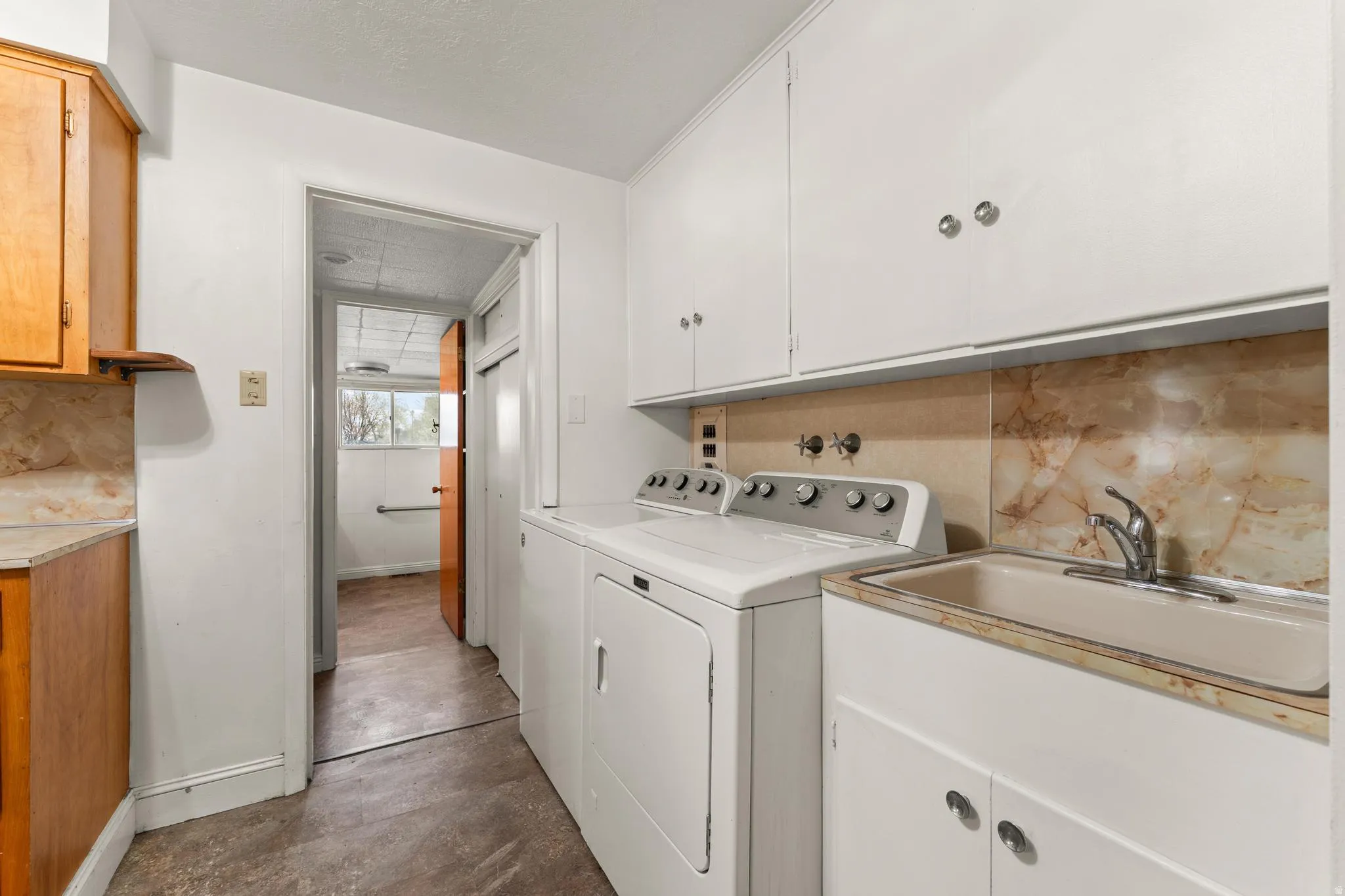 Laundry area featuring cabinet space, concrete flooring, and separate washer and dryer