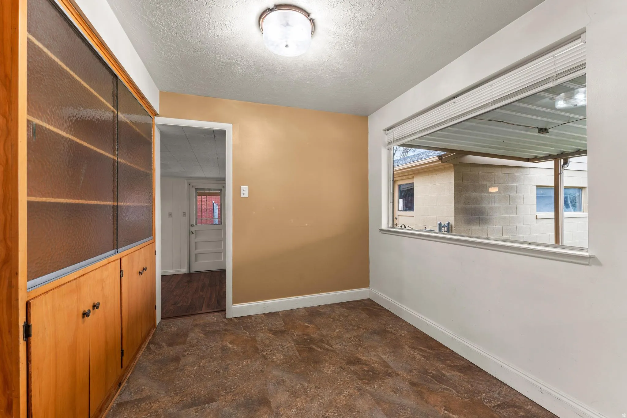 Hallway with stone finish flooring and a textured ceiling