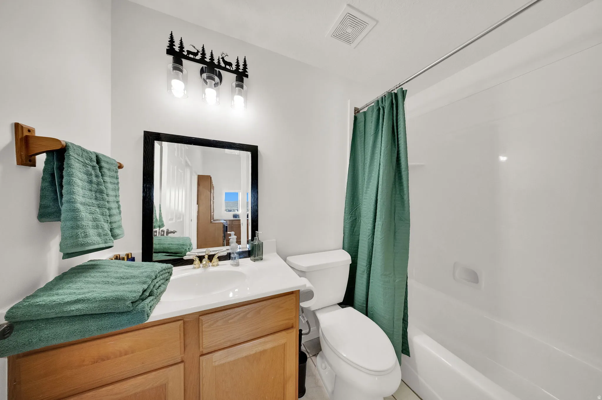 Bathroom featuring a light wood-finish vanity with a white countertop and integrated sink