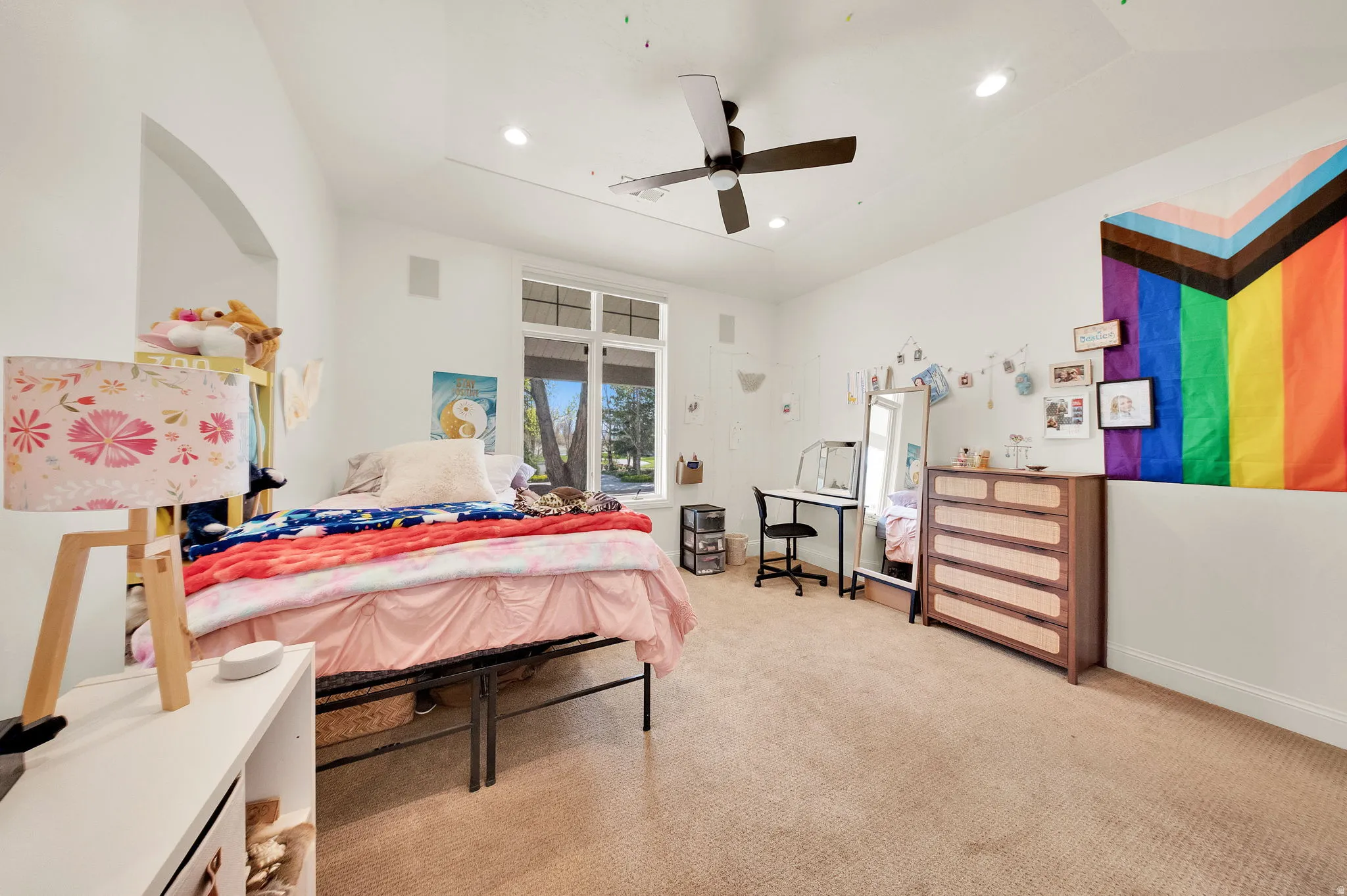 Carpeted room featuring a ceiling fan, recessed lighting, and a large window with multiple panes