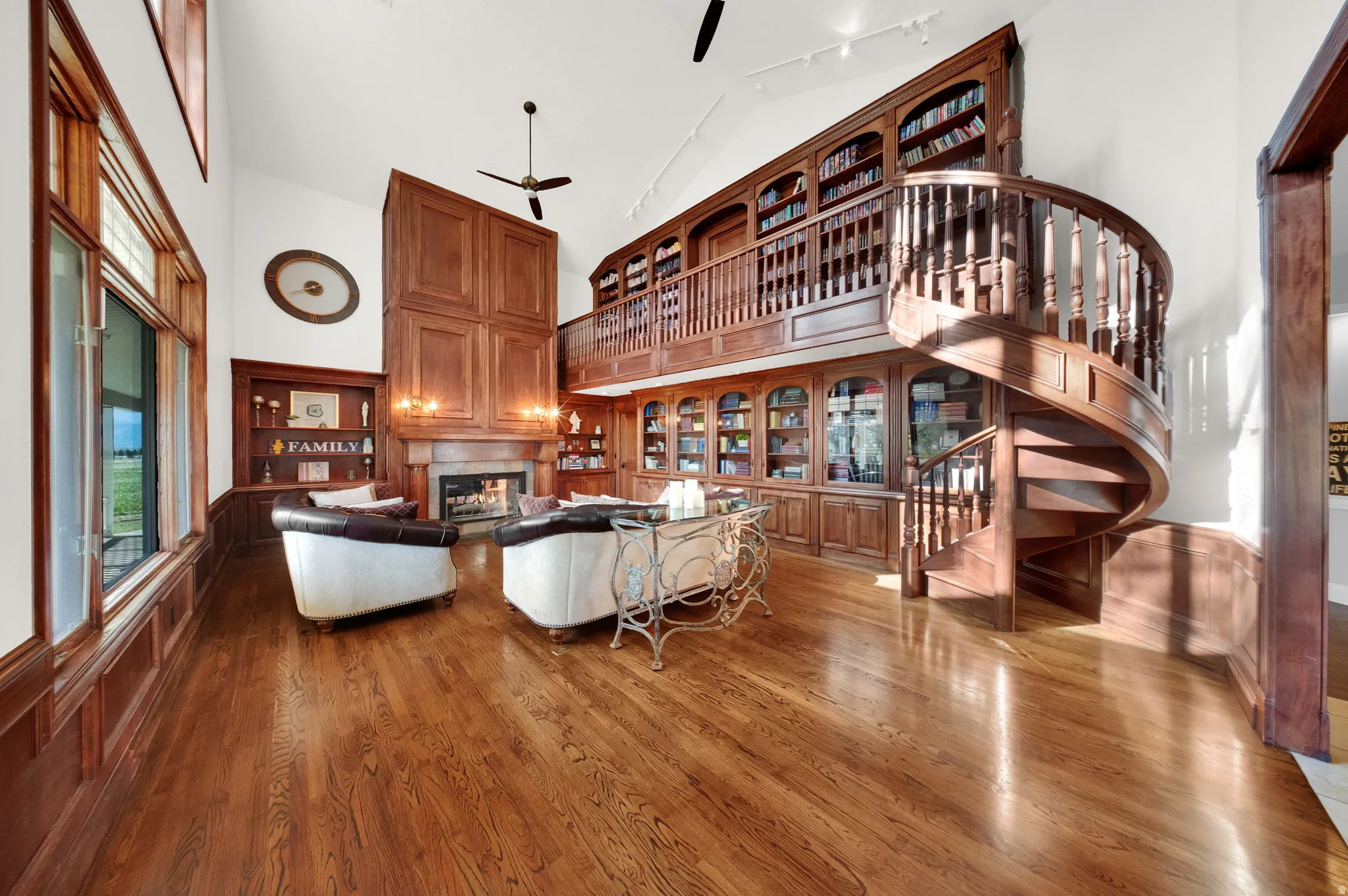 Grand living space featuring a custom-built two-story wood library with an integrated spiral staircase