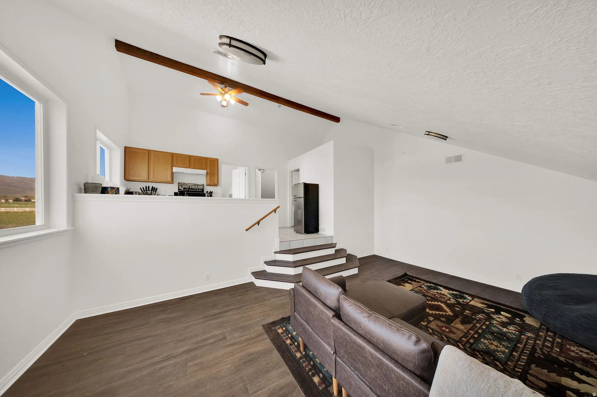 Vaulted ceiling with exposed wood beam and ceiling fan