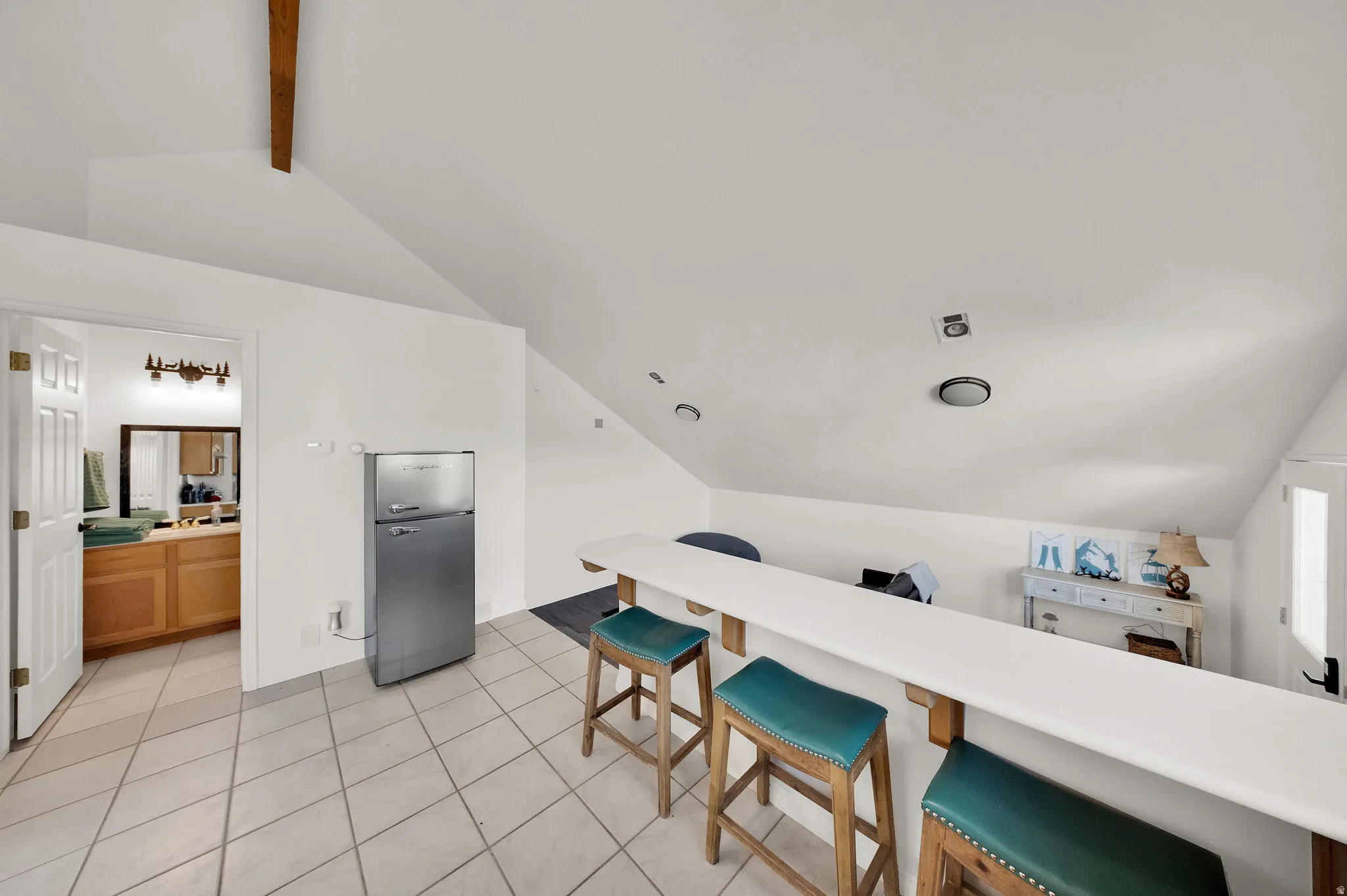 Loft space featuring a built-in bar with seating, recessed lighting, and a vaulted ceiling
