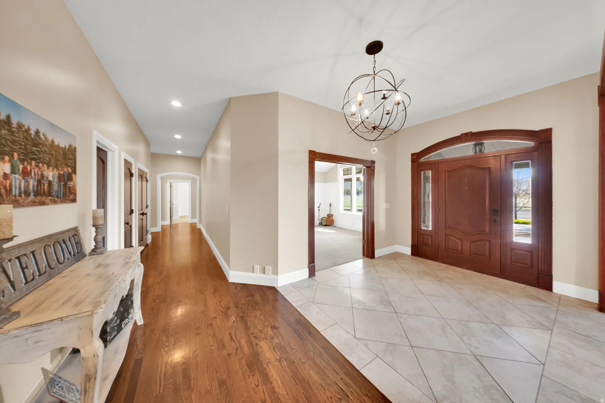 Grand entryway featuring a decorative wooden front door with sidelights