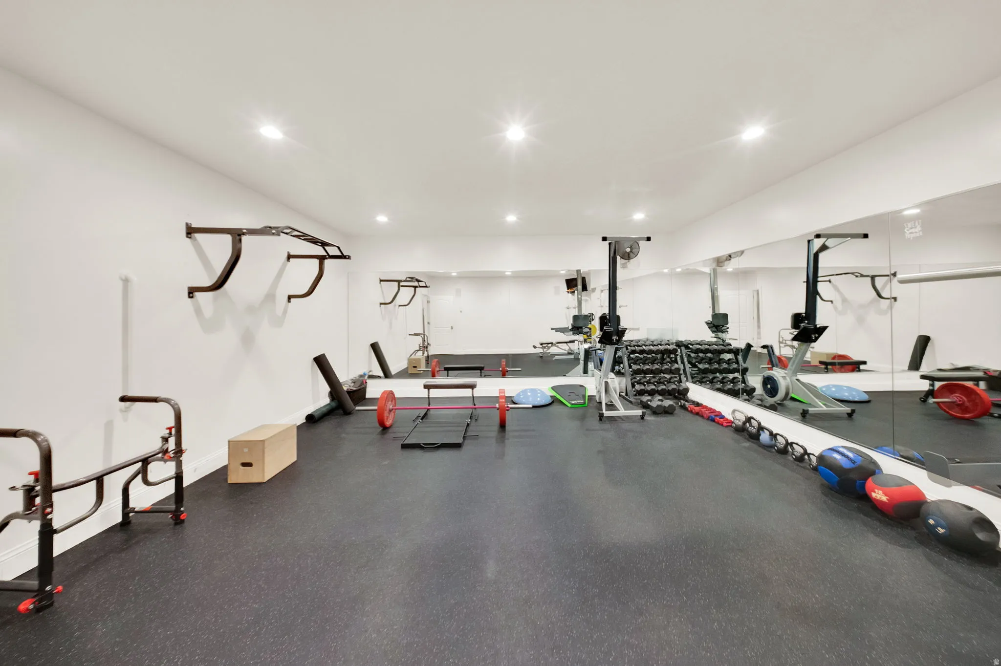 Dedicated fitness room featuring recessed lighting and extensive mirrored walls