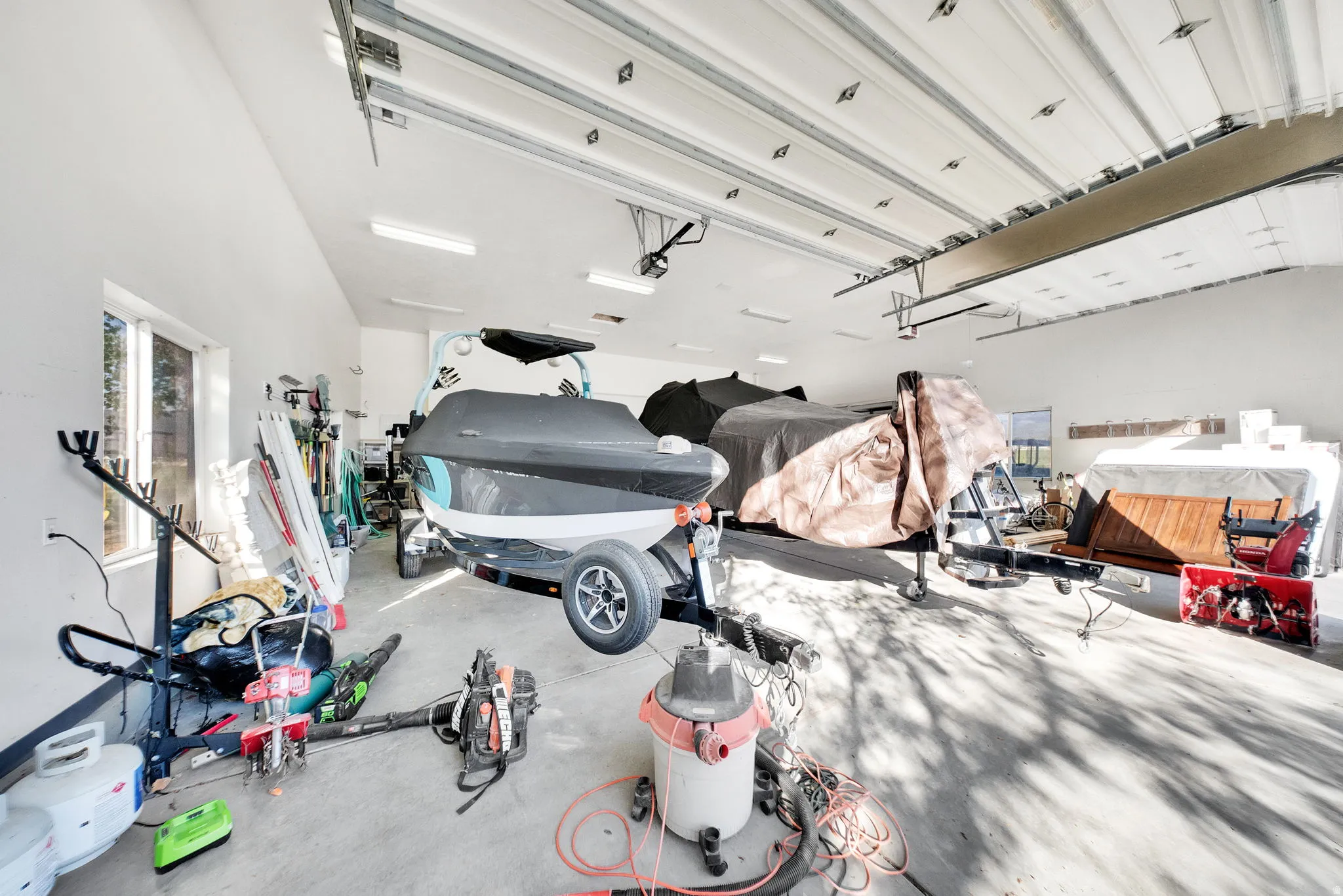Spacious garage with high ceilings, concrete flooring, and multiple windows