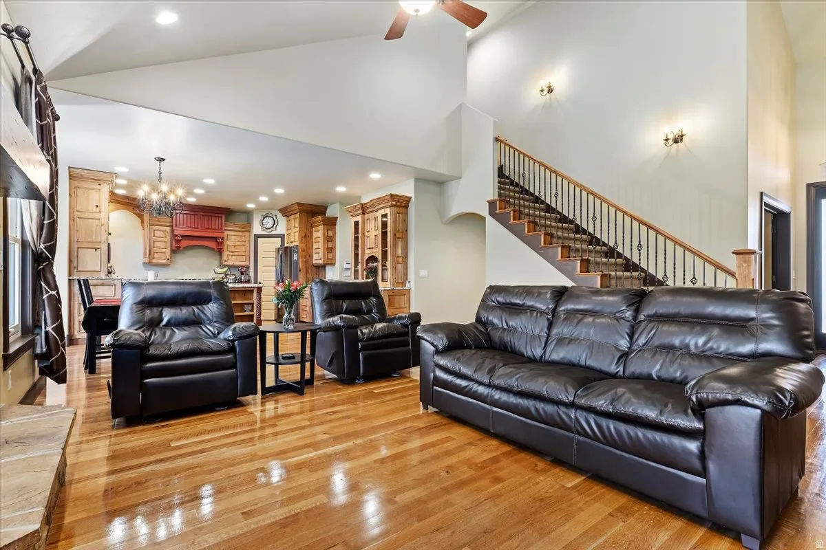 Spacious living area featuring wood-finish flooring, vaulted ceilings, and recessed lighting